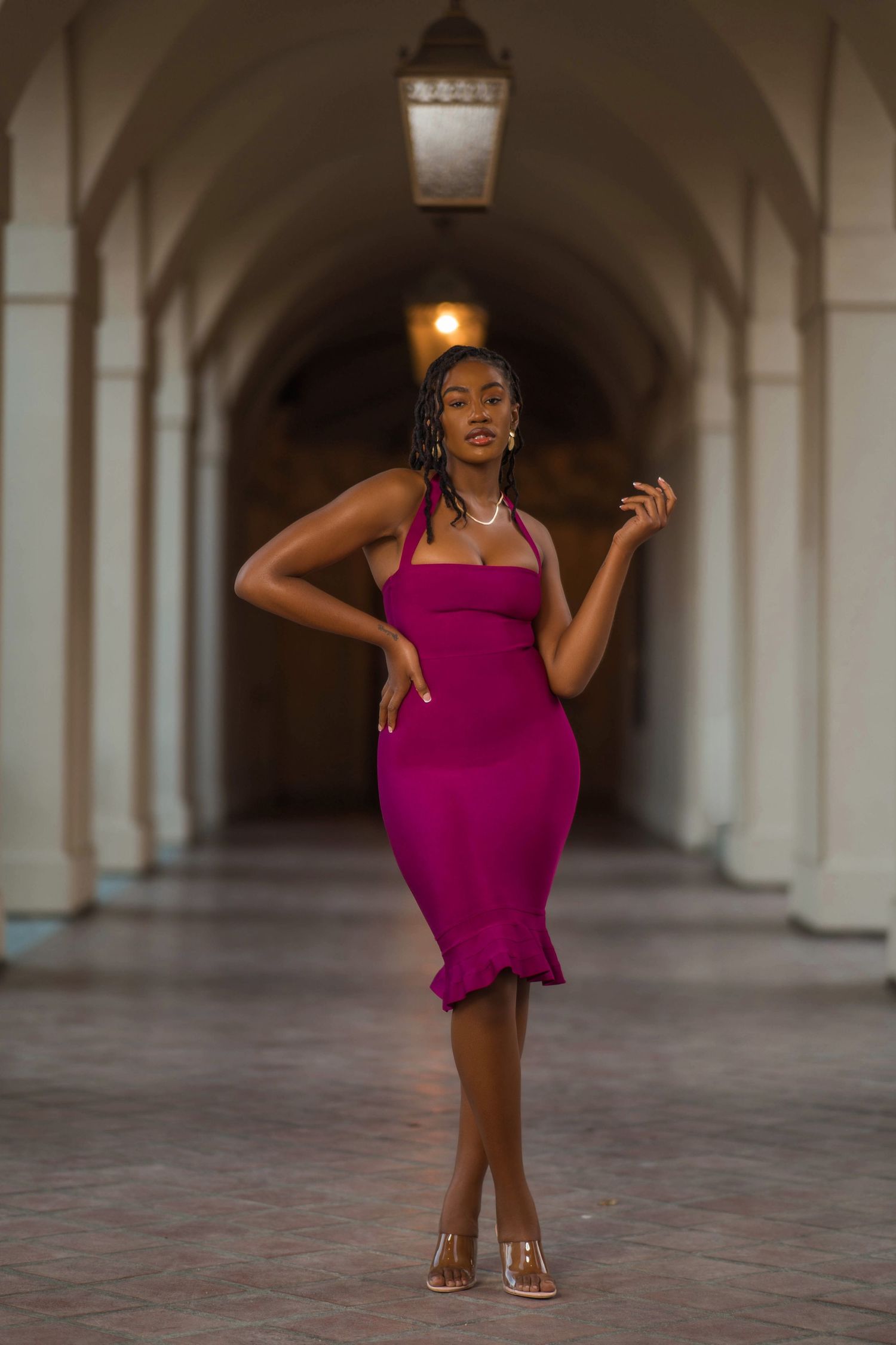 Figure in purple dress dances through elegant colonnade with arched architecture.