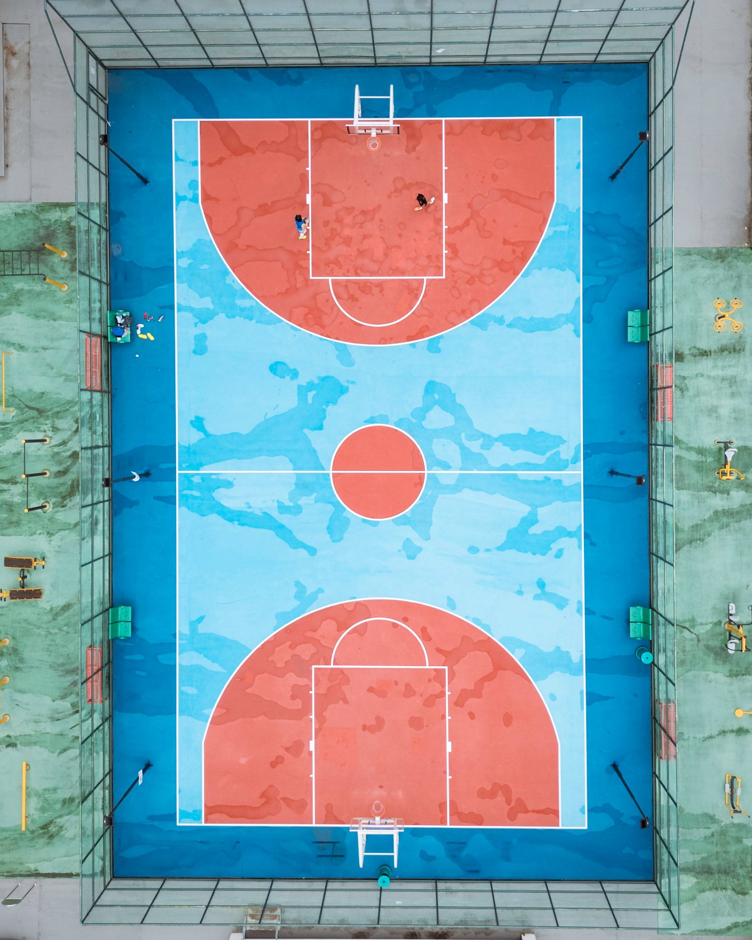 Colorful basketball and sports courts with blue and red surfaces seen from above.