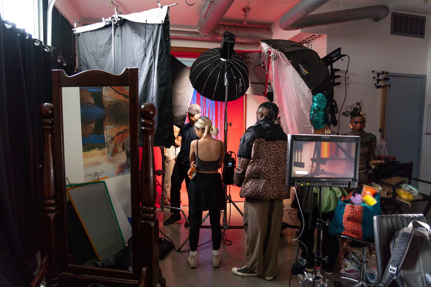 Behind the scenes view of a film production set with crew and equipment in dim lighting.