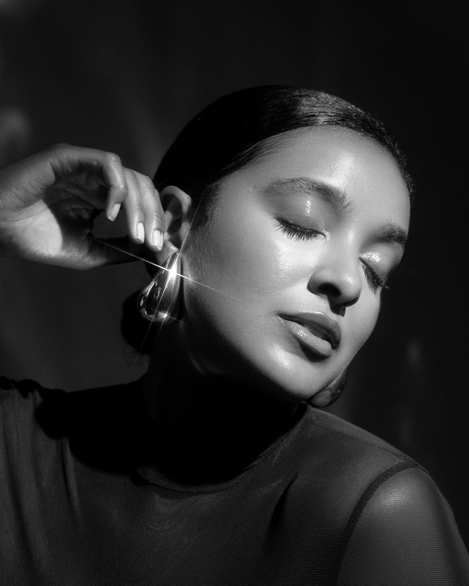 Elegant black and white portrait showing profile view with statement earring.