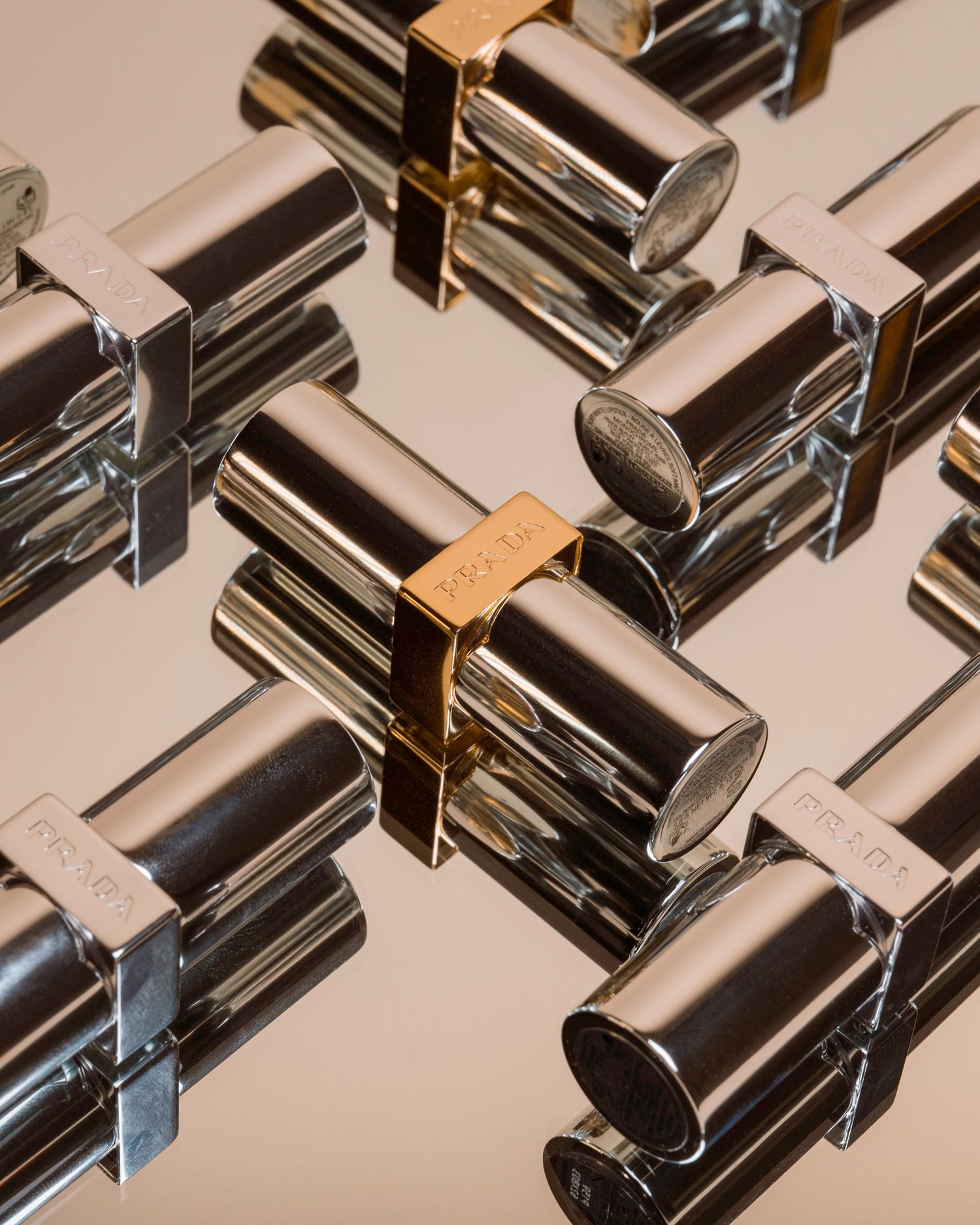 Row of luxury metallic lipstick tubes arranged in diagonal pattern.