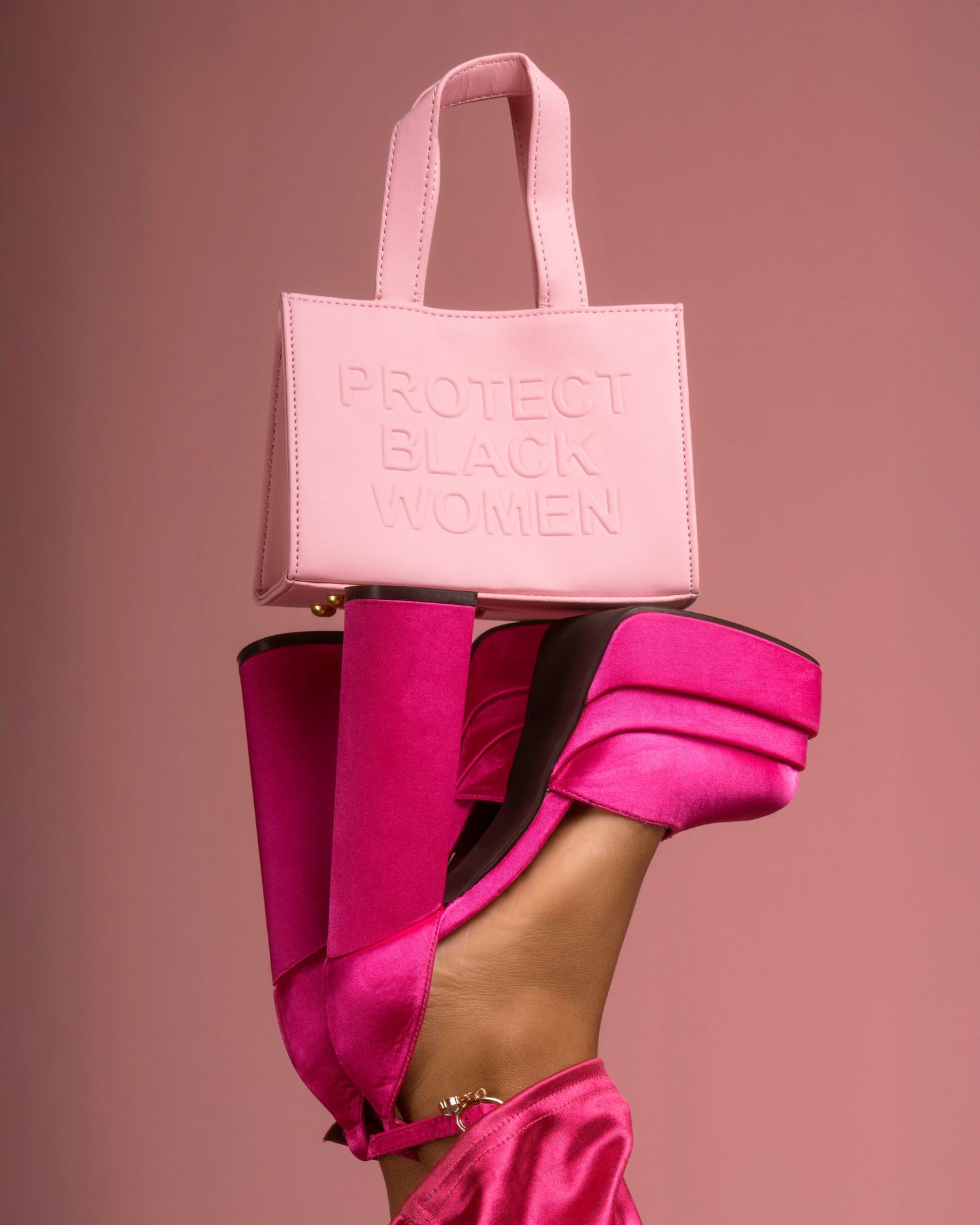 Pink embossed handbag paired with bright pink platform heels in artistic product shot.