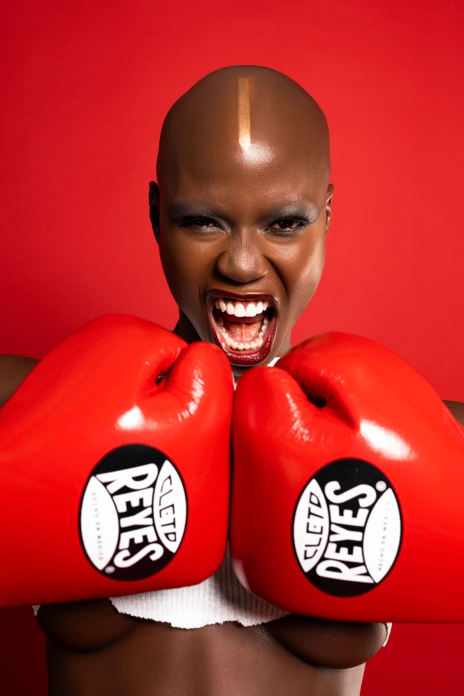 Close-up shot showing red boxing gloves against crimson background with dramatic expression.