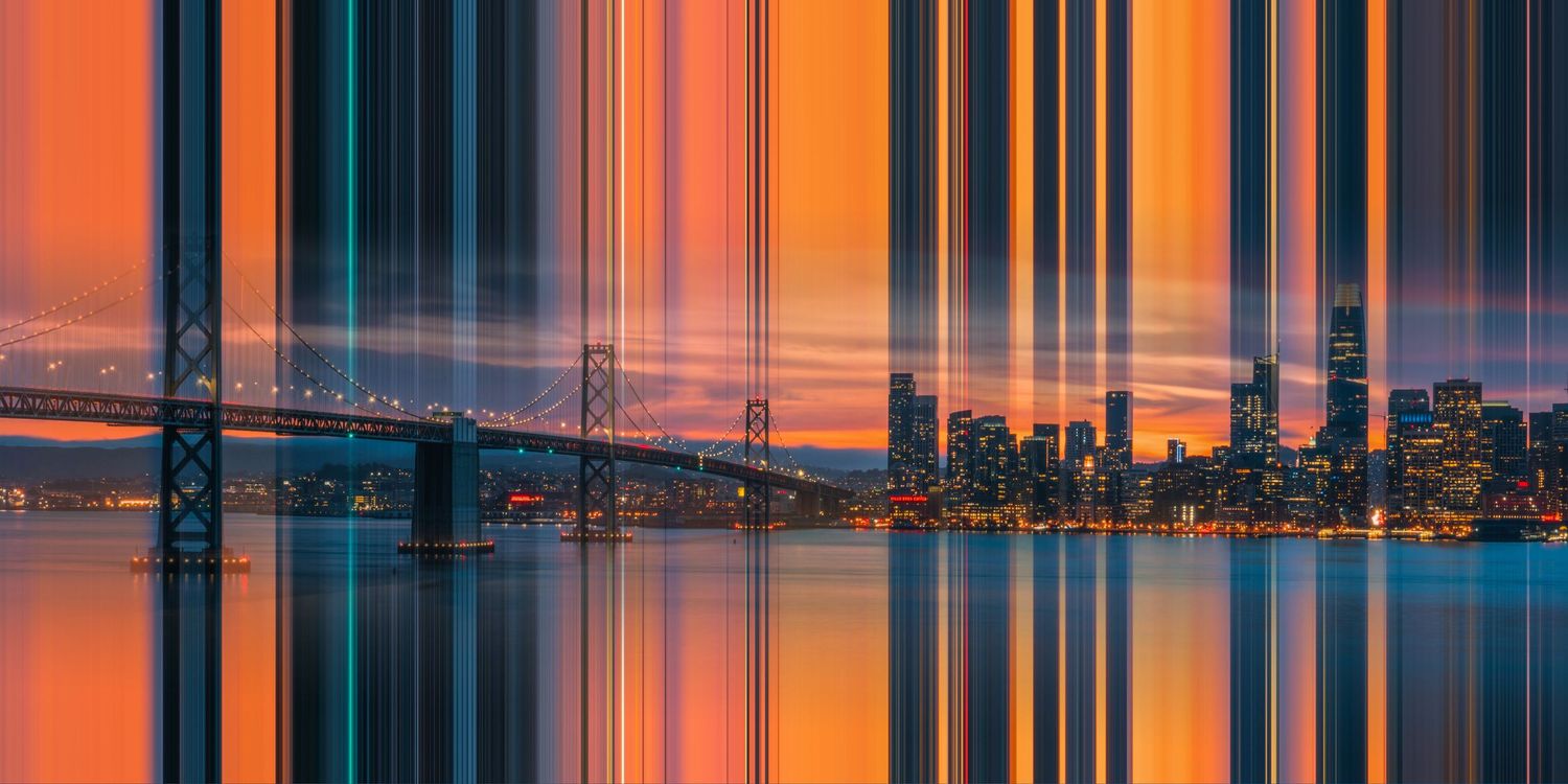 Vertical motion blur cityscape of San Francisco and Bay Bridge at sunset with orange and blue reflections.