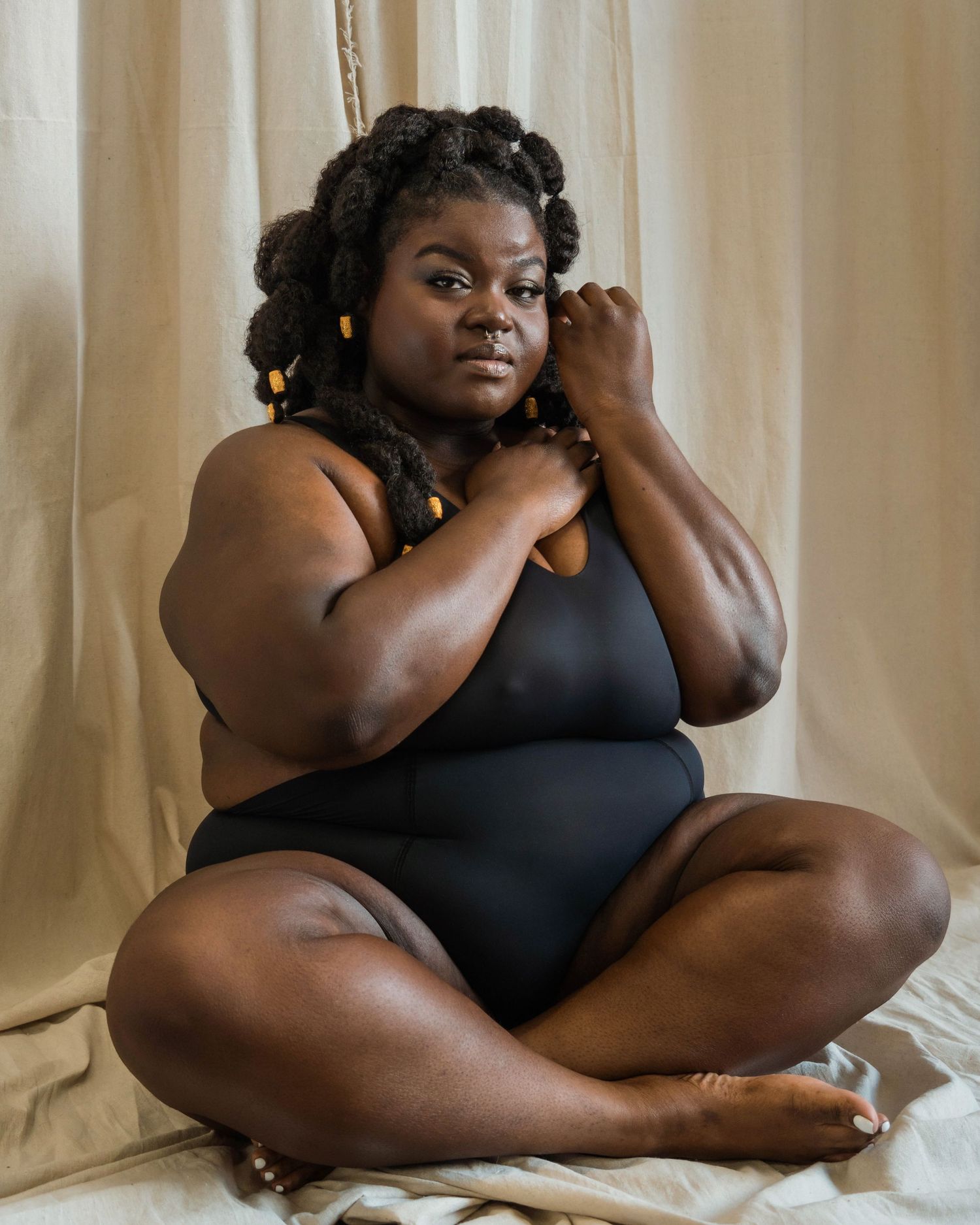 Intimate boudoir photography session with black lingerie against neutral backdrop.