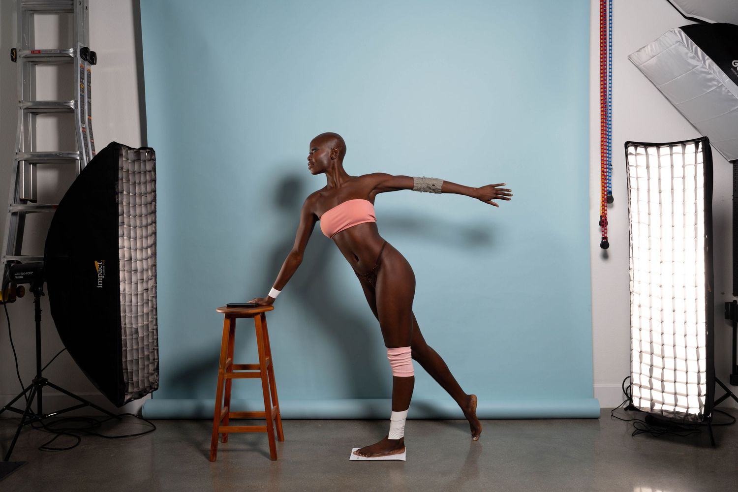 Dance sequence showing graceful movements in a studio setting with lighting equipment visible.