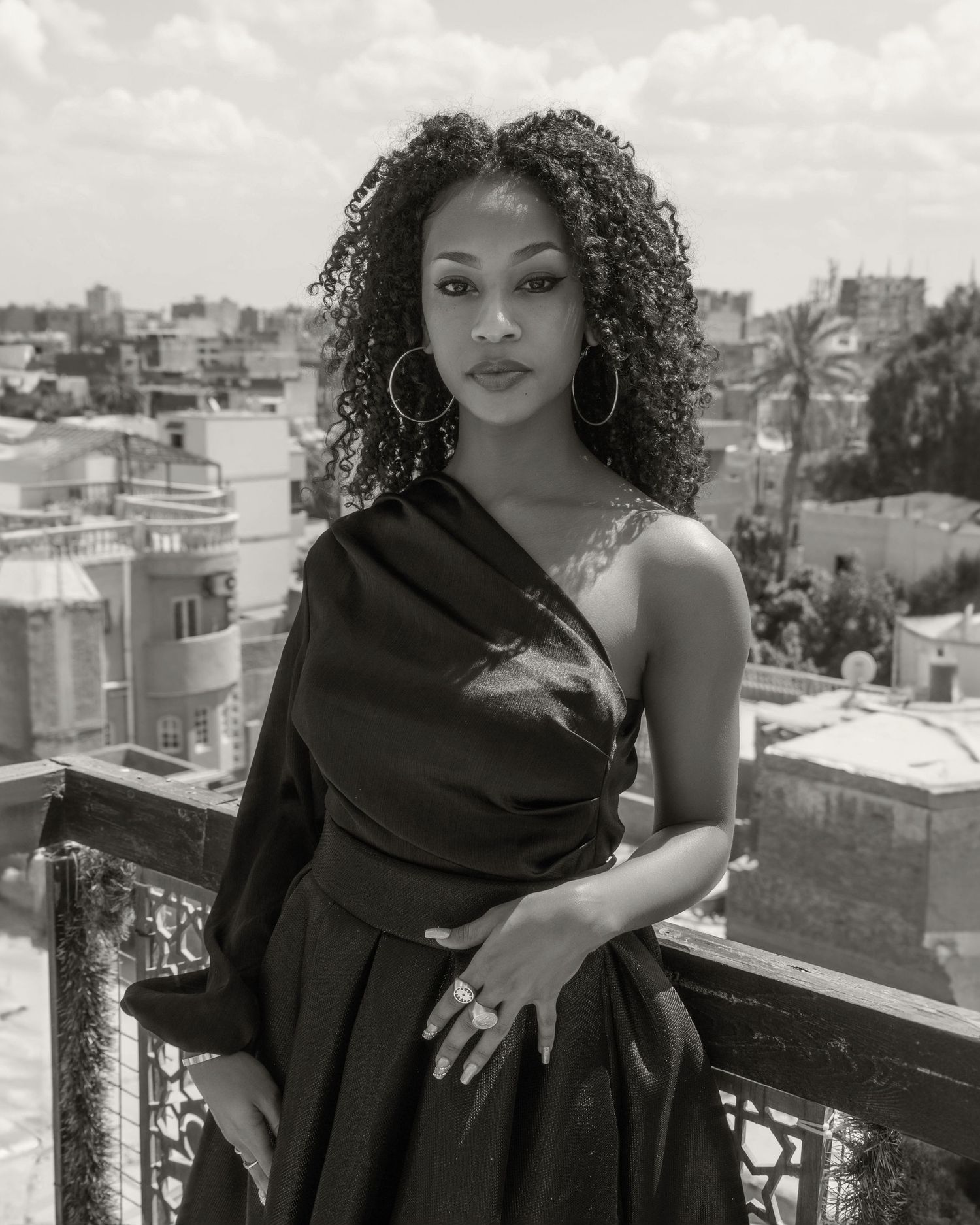 Black and white rooftop fashion portraits with urban backdrop.