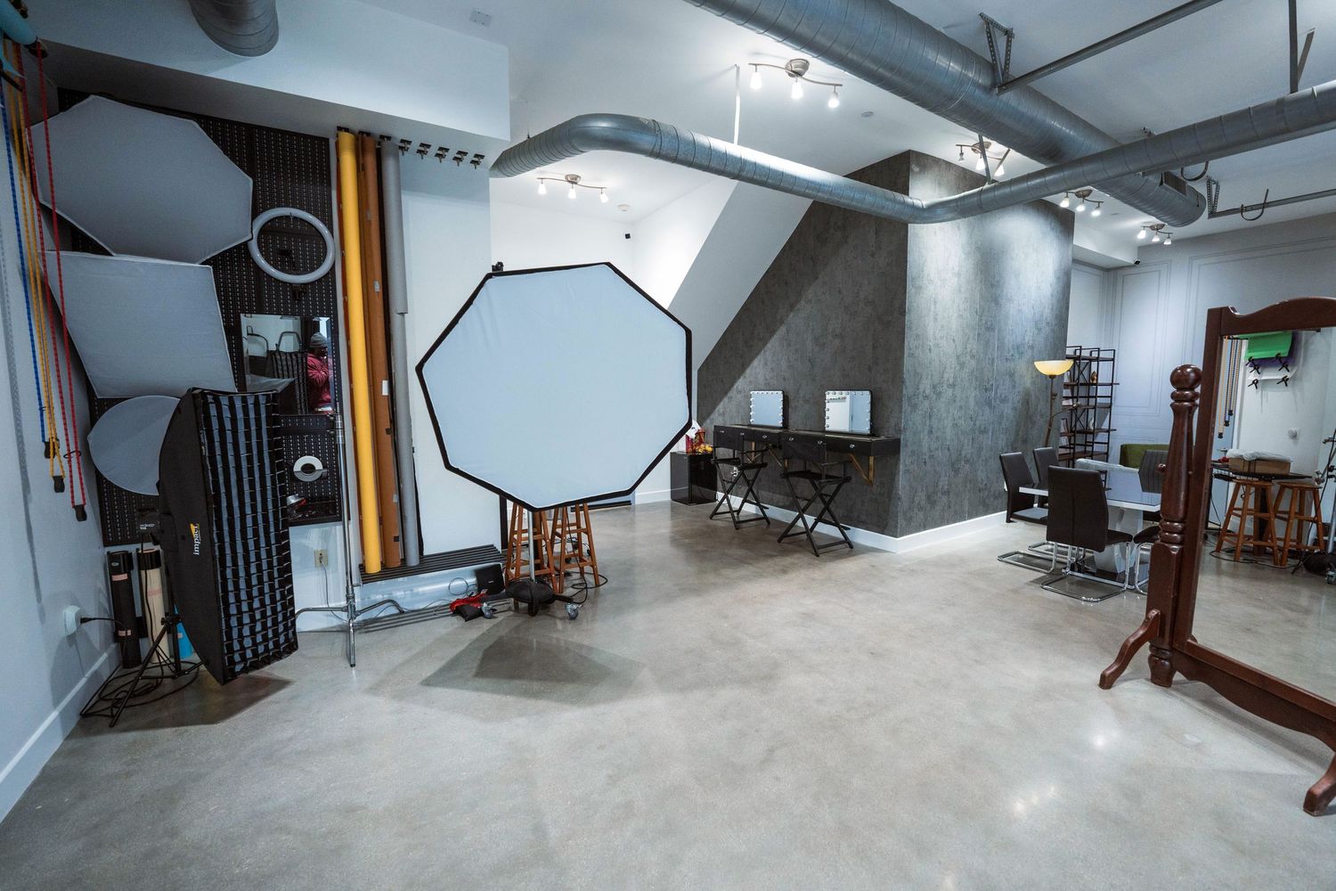 Professional photography studio with large octabox light, reflectors, and equipment on polished concrete floors.
