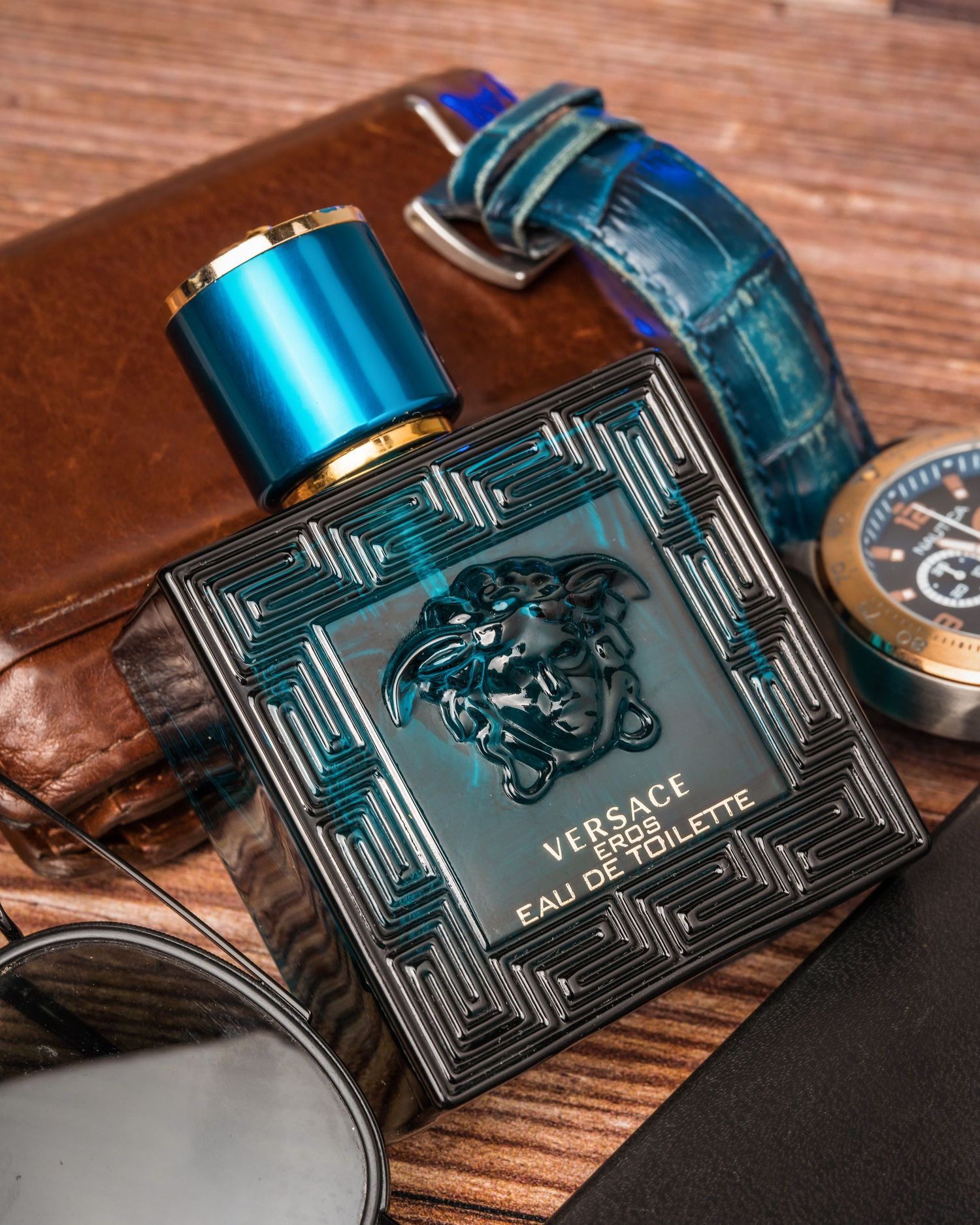 Versace perfume bottle with geometric pattern displayed on wooden surface.