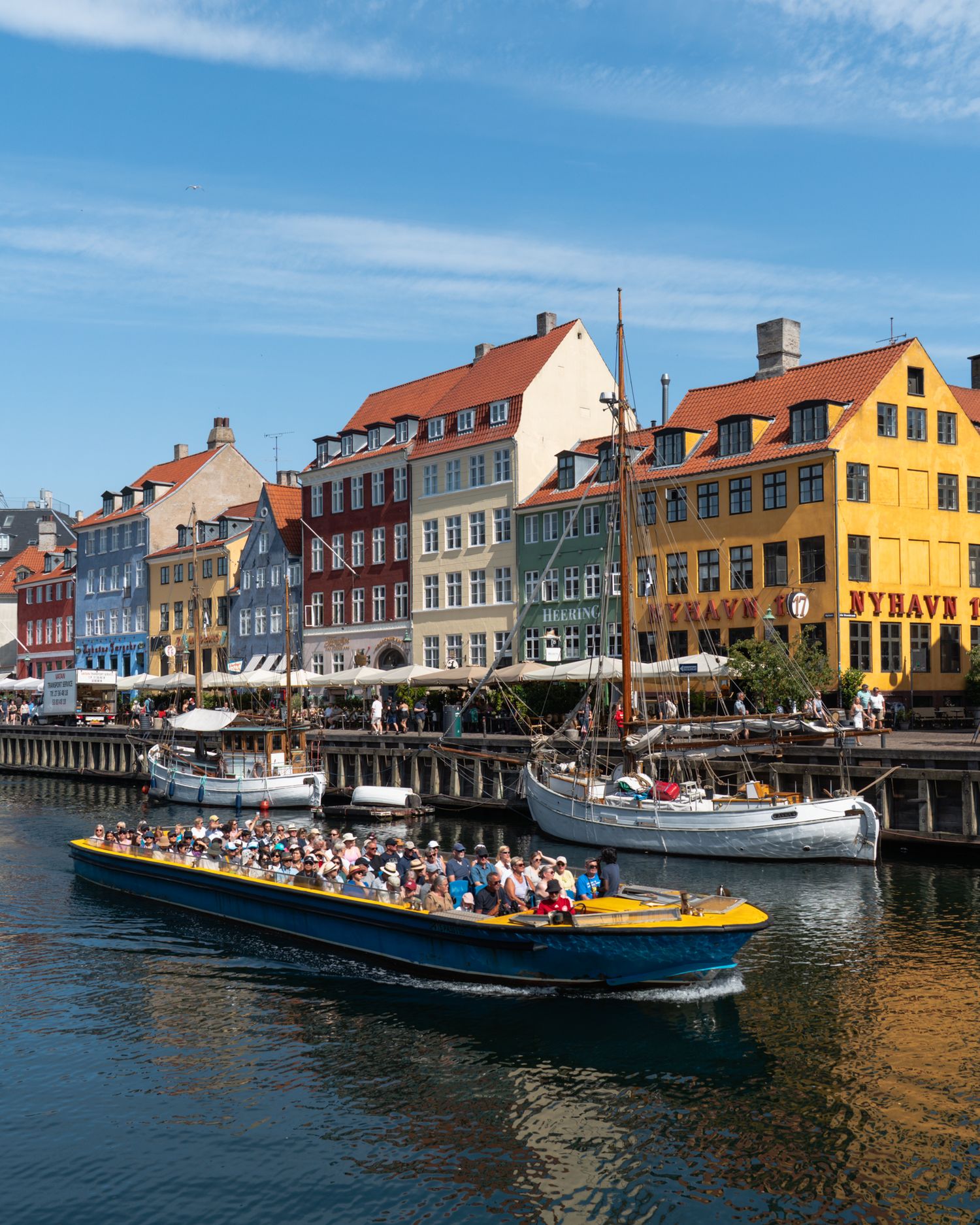 Tourist boats and colorful historic buildings line the waterfront of Copenhagen's Nyhavn canal.