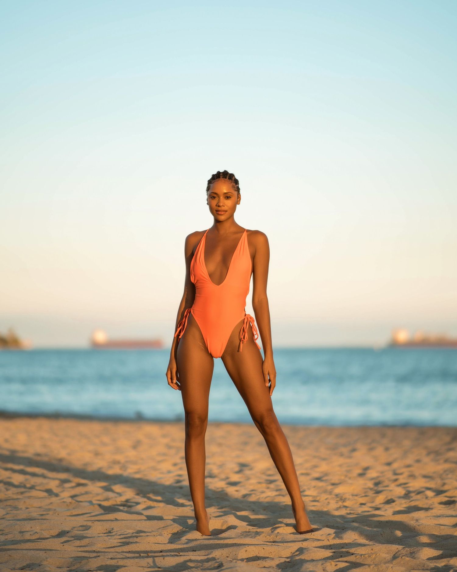 Athletic poses captured during sunset beach photoshoot with ocean in background.