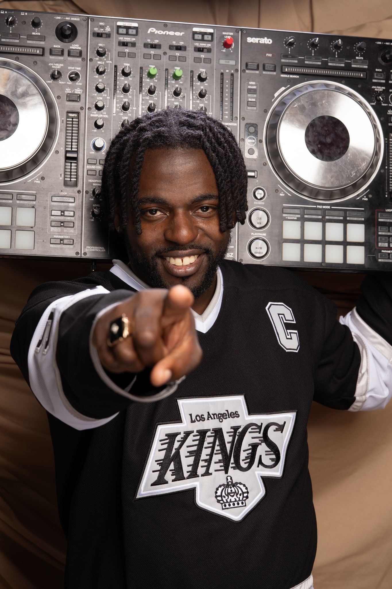 A series of four photos showing a DJ posing with professional music equipment and turntables in a studio setting.