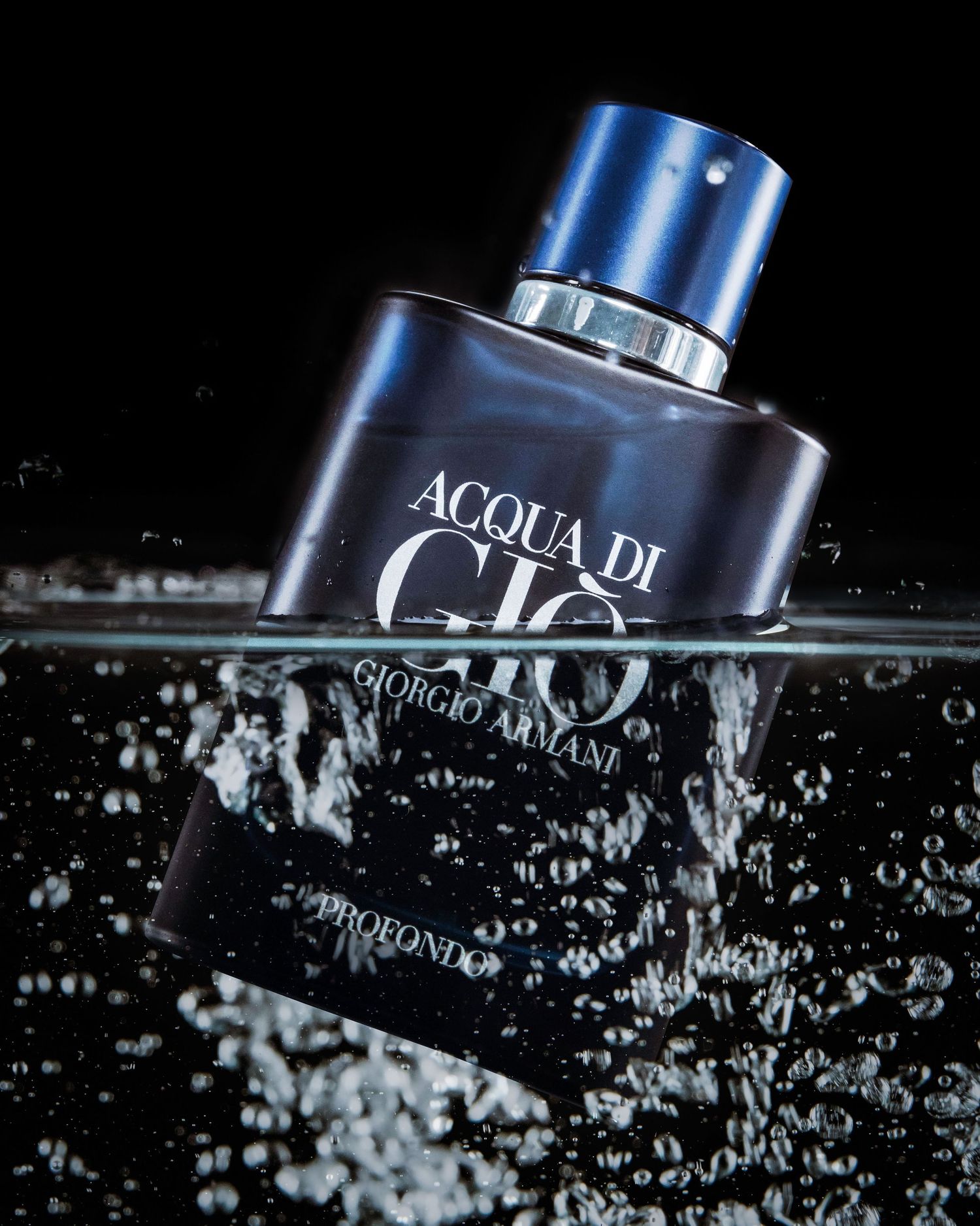 Luxury fragrance bottle partially submerged in water with dramatic splash effect.