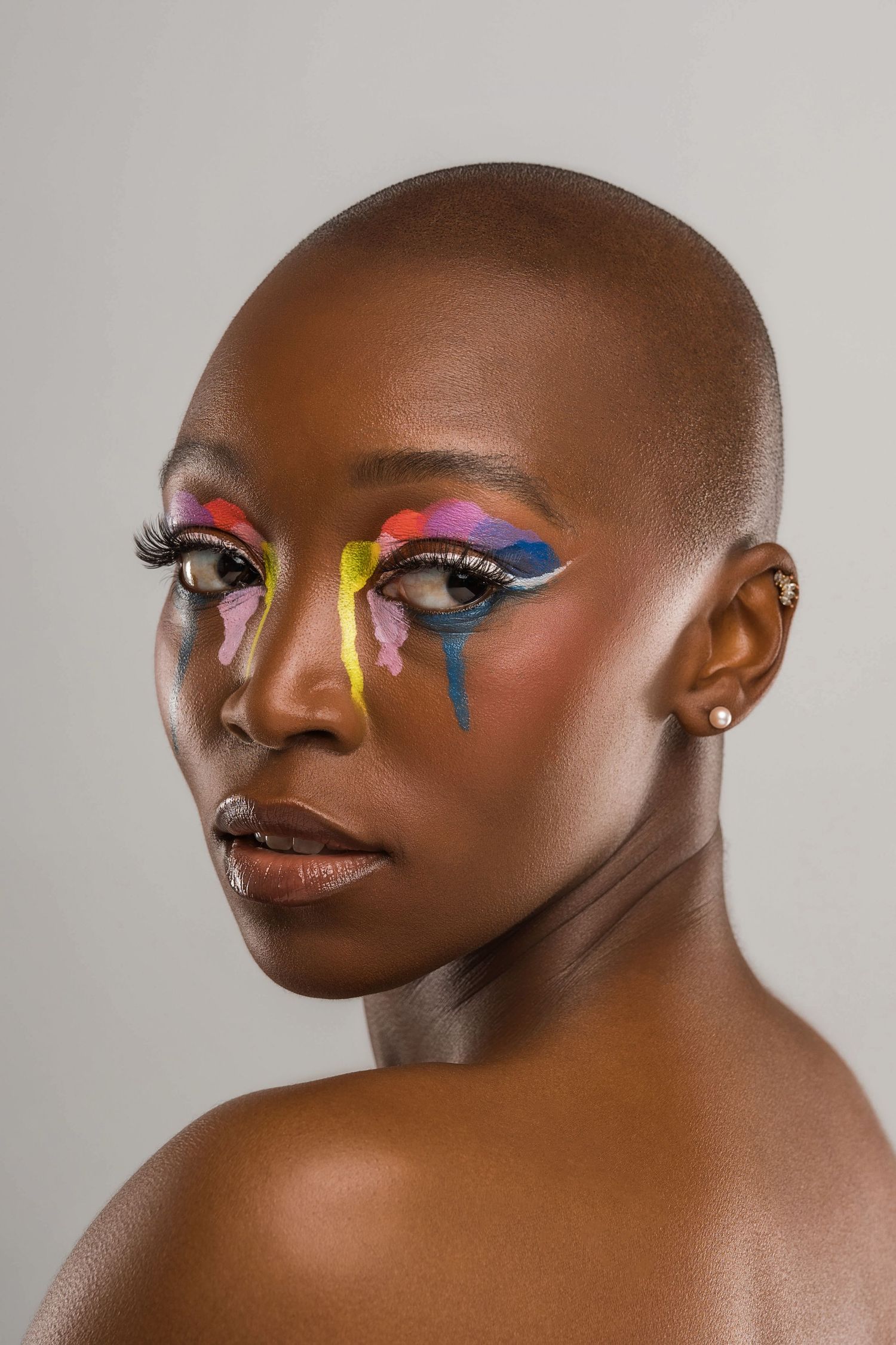 Artistic beauty portraits featuring abstract colorful eye makeup with dripping paint effect.