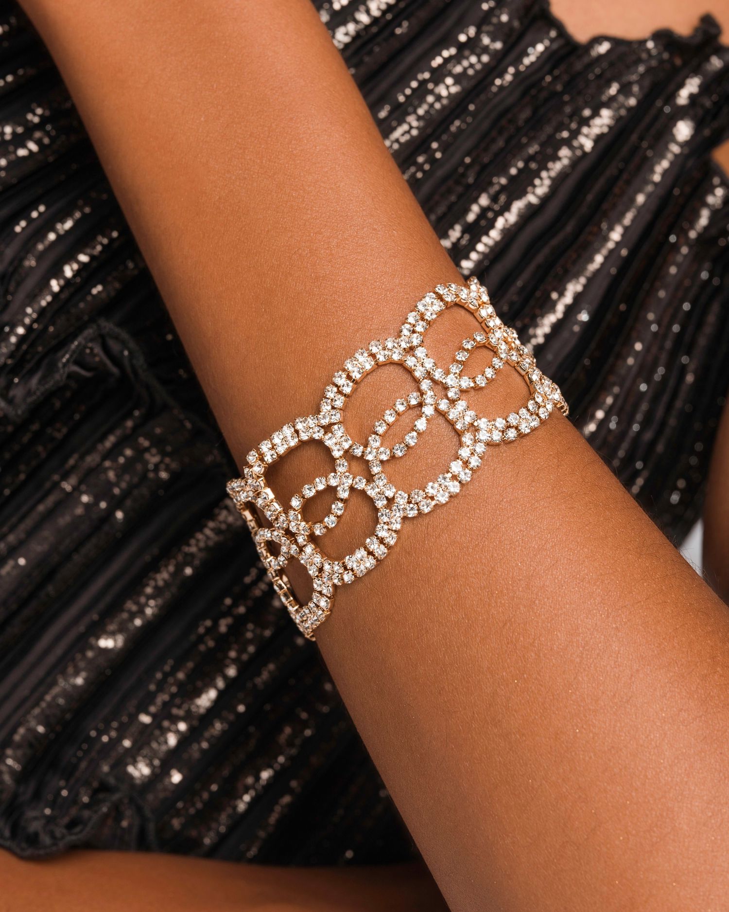 Crystal chain link bracelet shown against black pleated fabric.