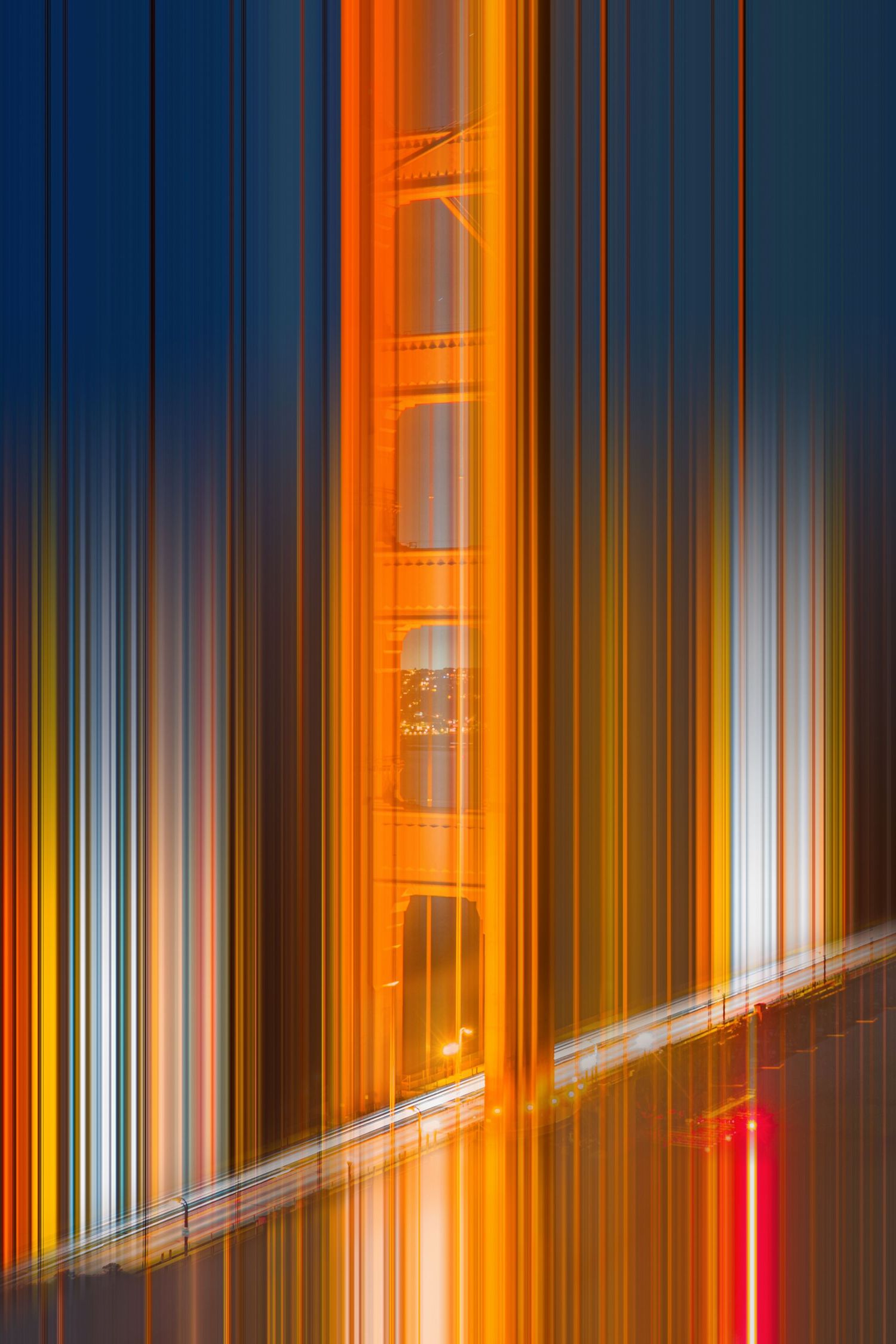 Abstract motion blur photograph of the Golden Gate Bridge tower glowing orange against a dark blue sky.