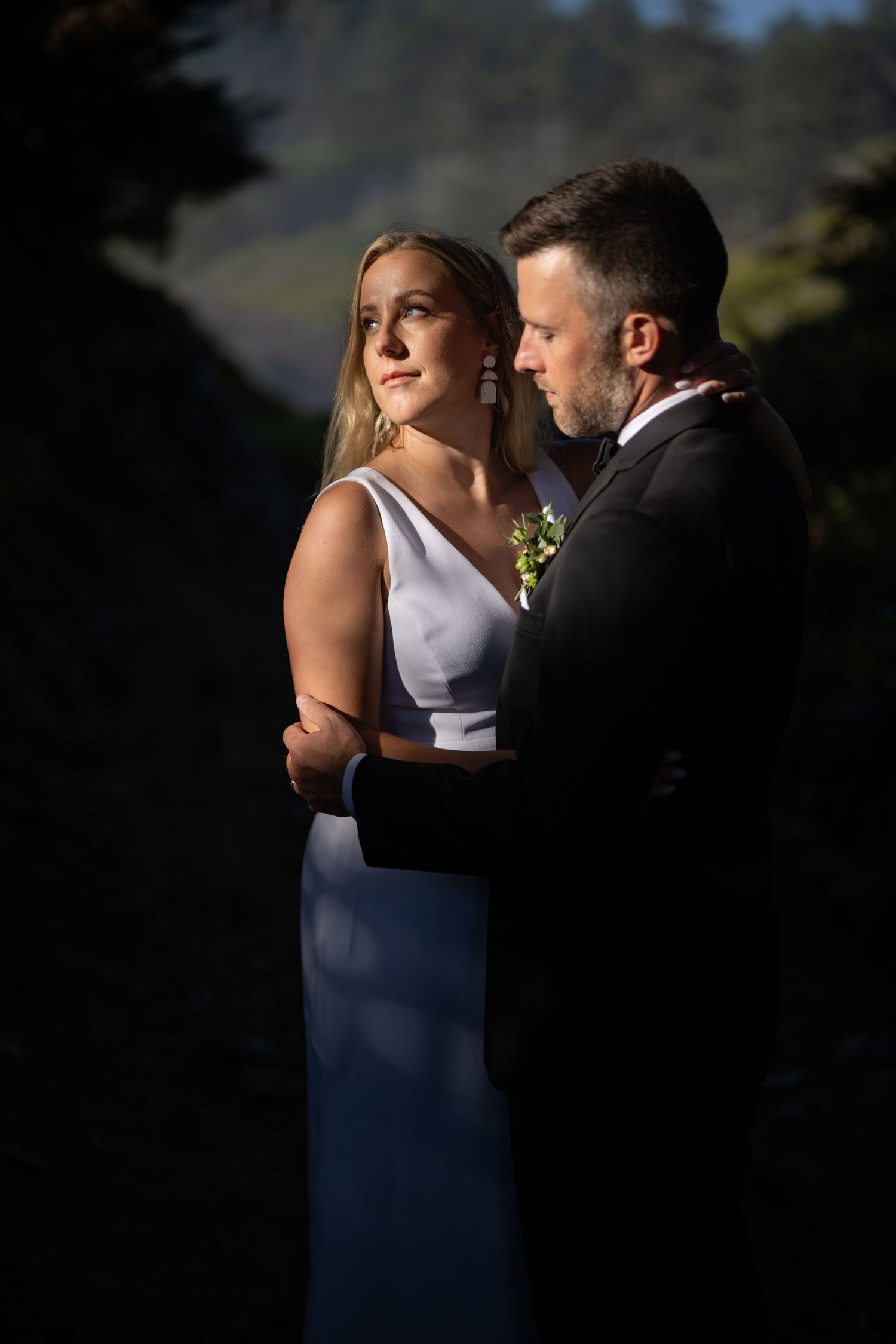Intimate wedding portrait with dramatic lighting and shadows.