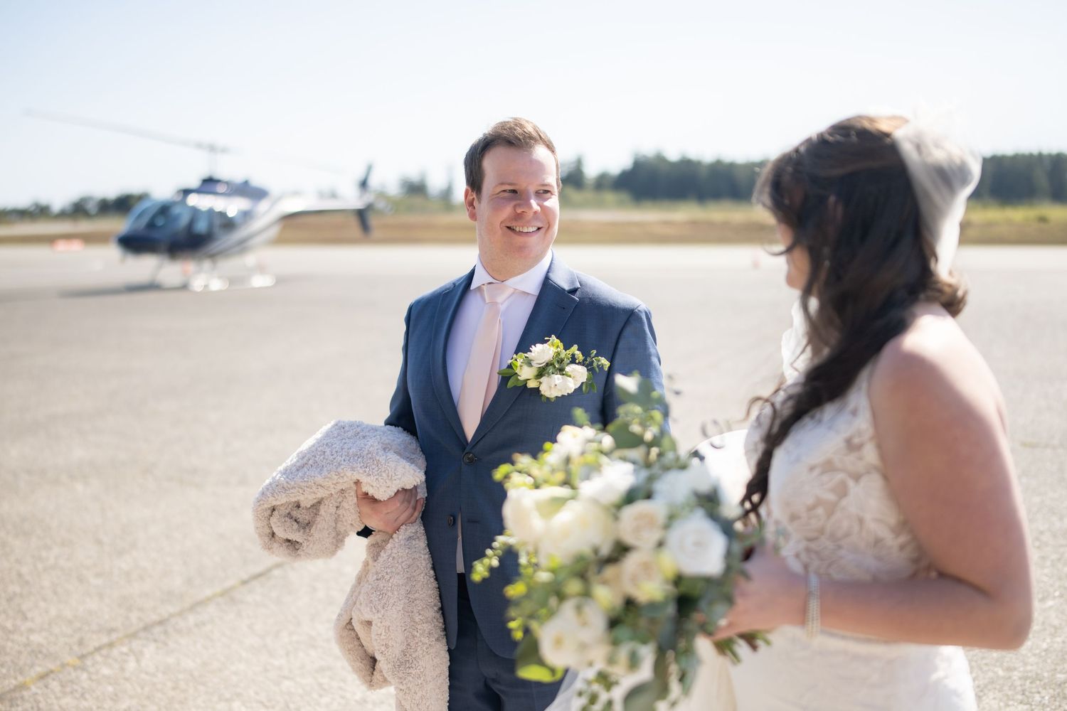 Wedding couple in formal attire exchanging documents during outdoor ceremony.