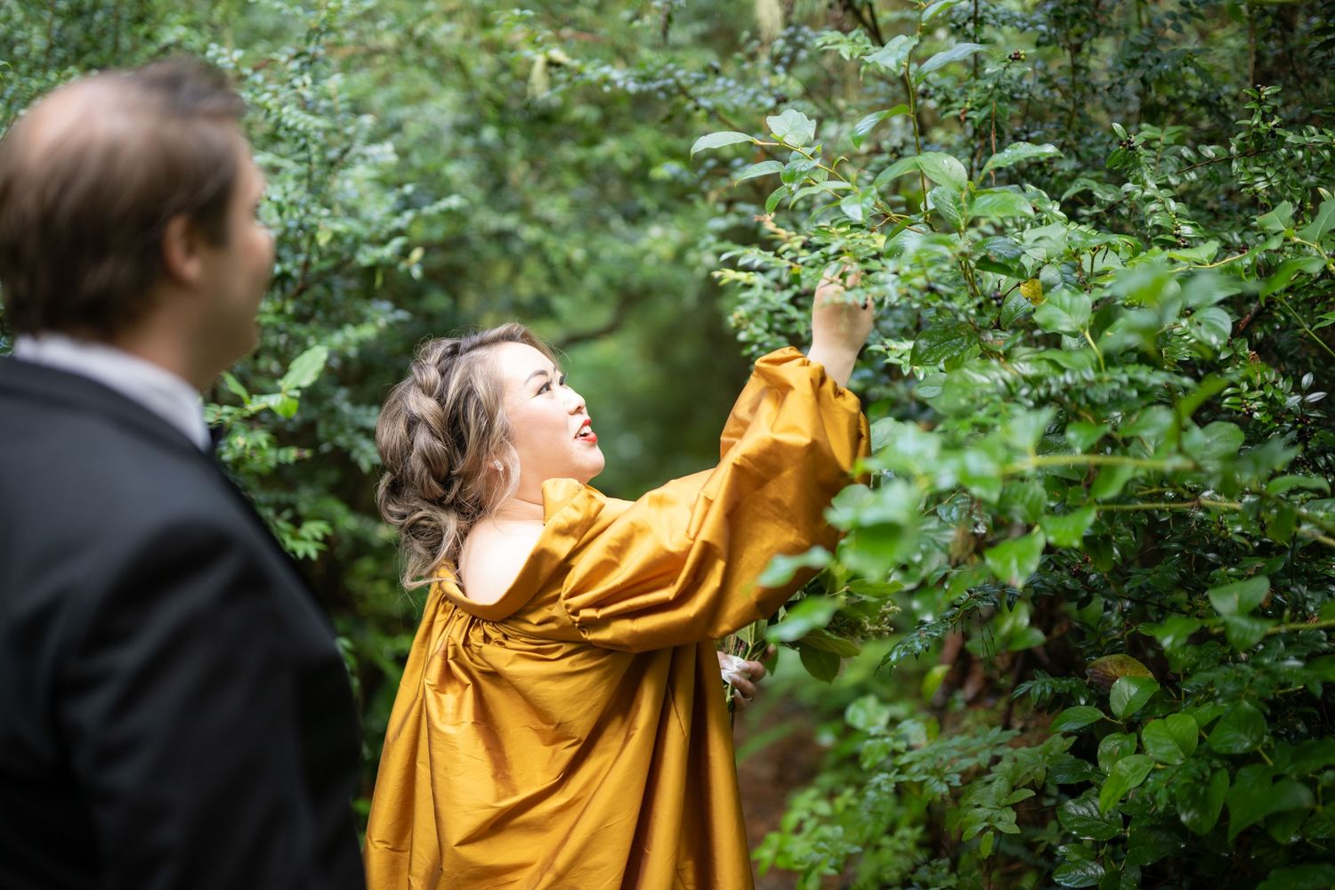 A vibrant yellow dress contrasts with lush green foliage in an outdoor setting.