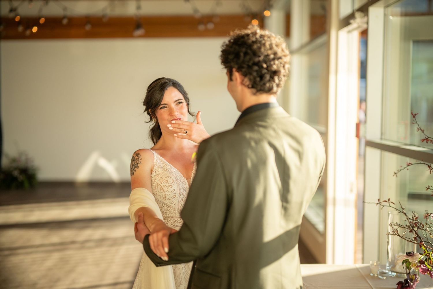 Wedding celebration in a bright venue with large windows and romantic lighting.
