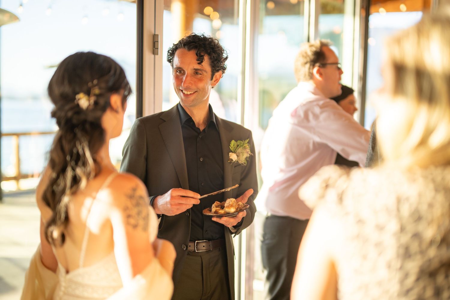 Guests mingling at an indoor wedding reception with warm ambient lighting.