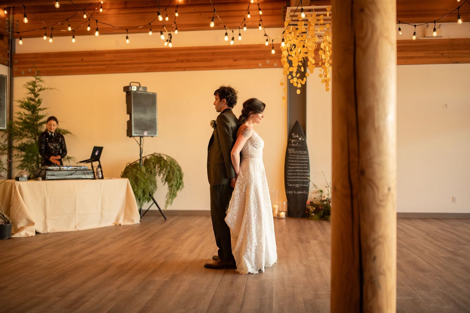 Wedding venue interior with wooden beams and twinkling string lights creating warm ambiance.