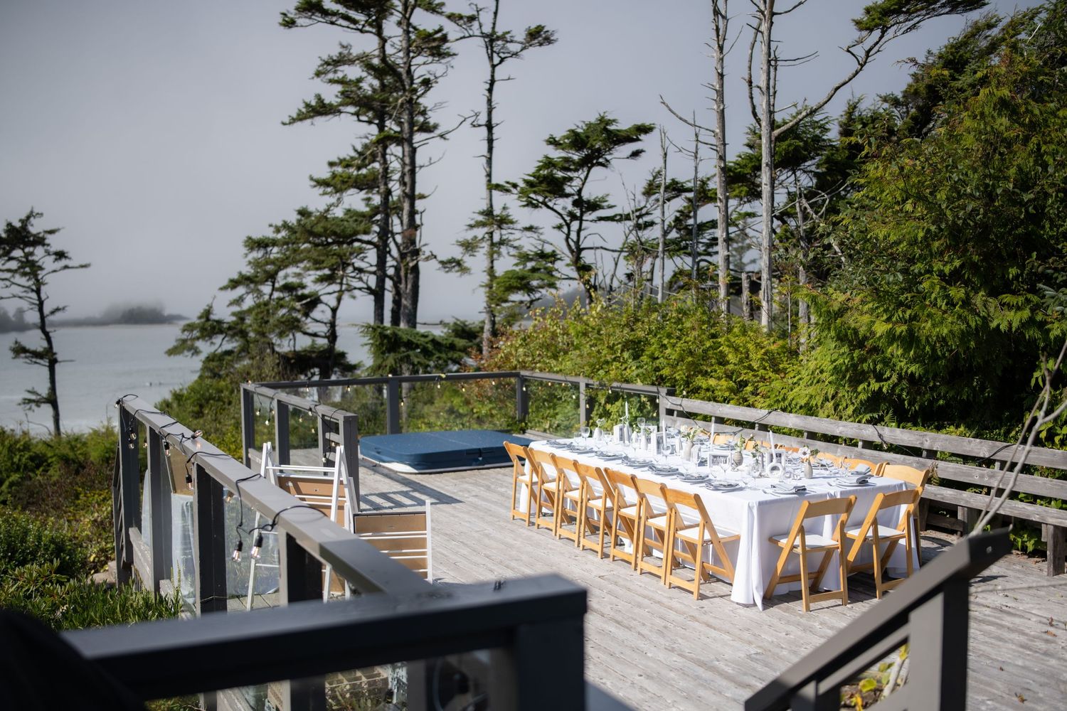 Outdoor wedding venue setup with wooden chairs and ocean view.