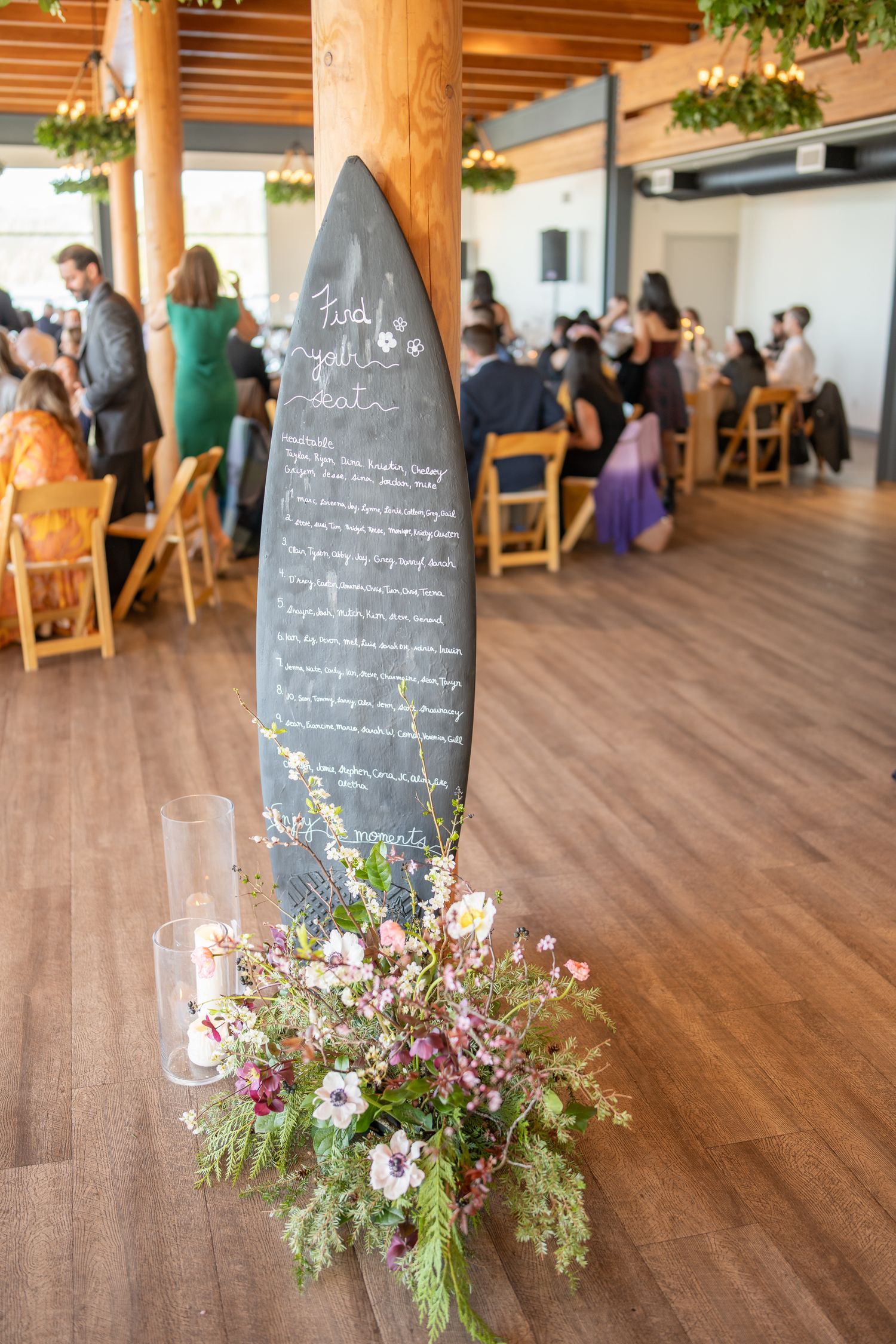 Decorative surfboard menu display with wildflower arrangement at reception.
