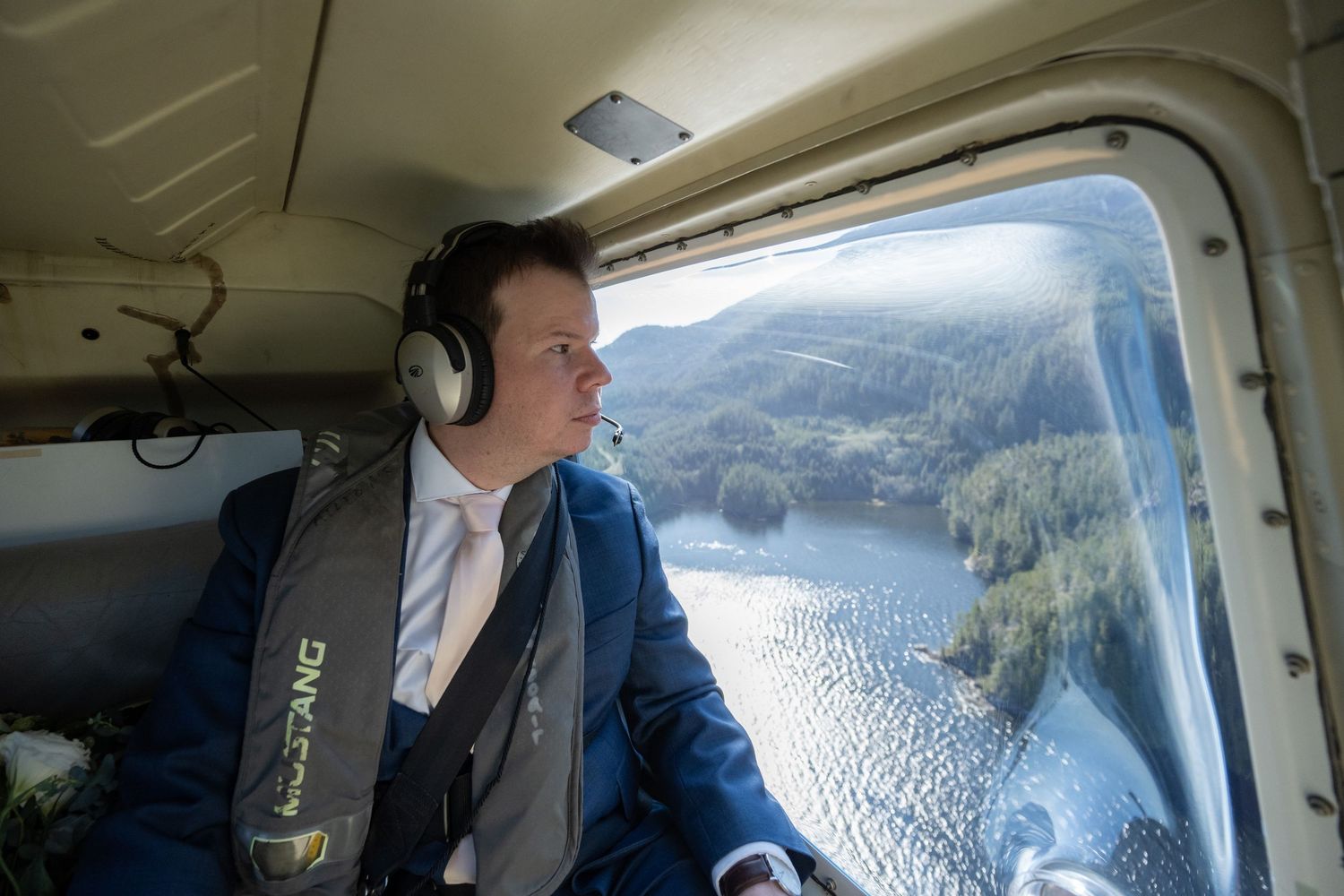 Passengers enjoying scenic views from inside helicopter during mountain flight.