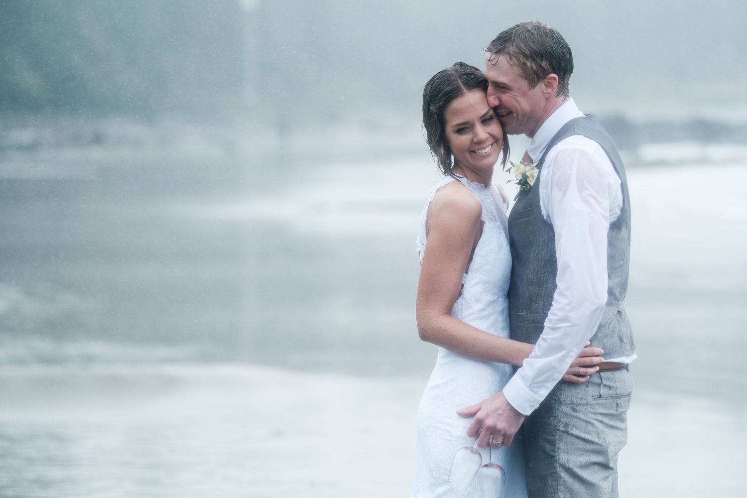 Romantic couple shares an intimate moment on a misty beach.