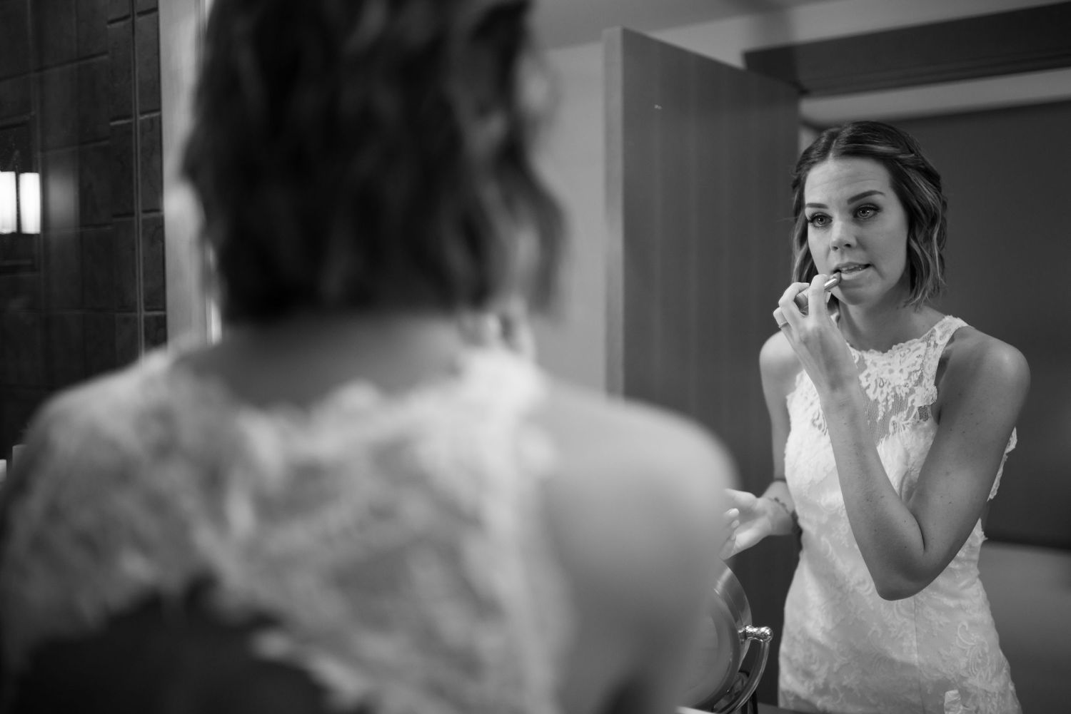 A bride in a white lace dress prepares for her wedding day.