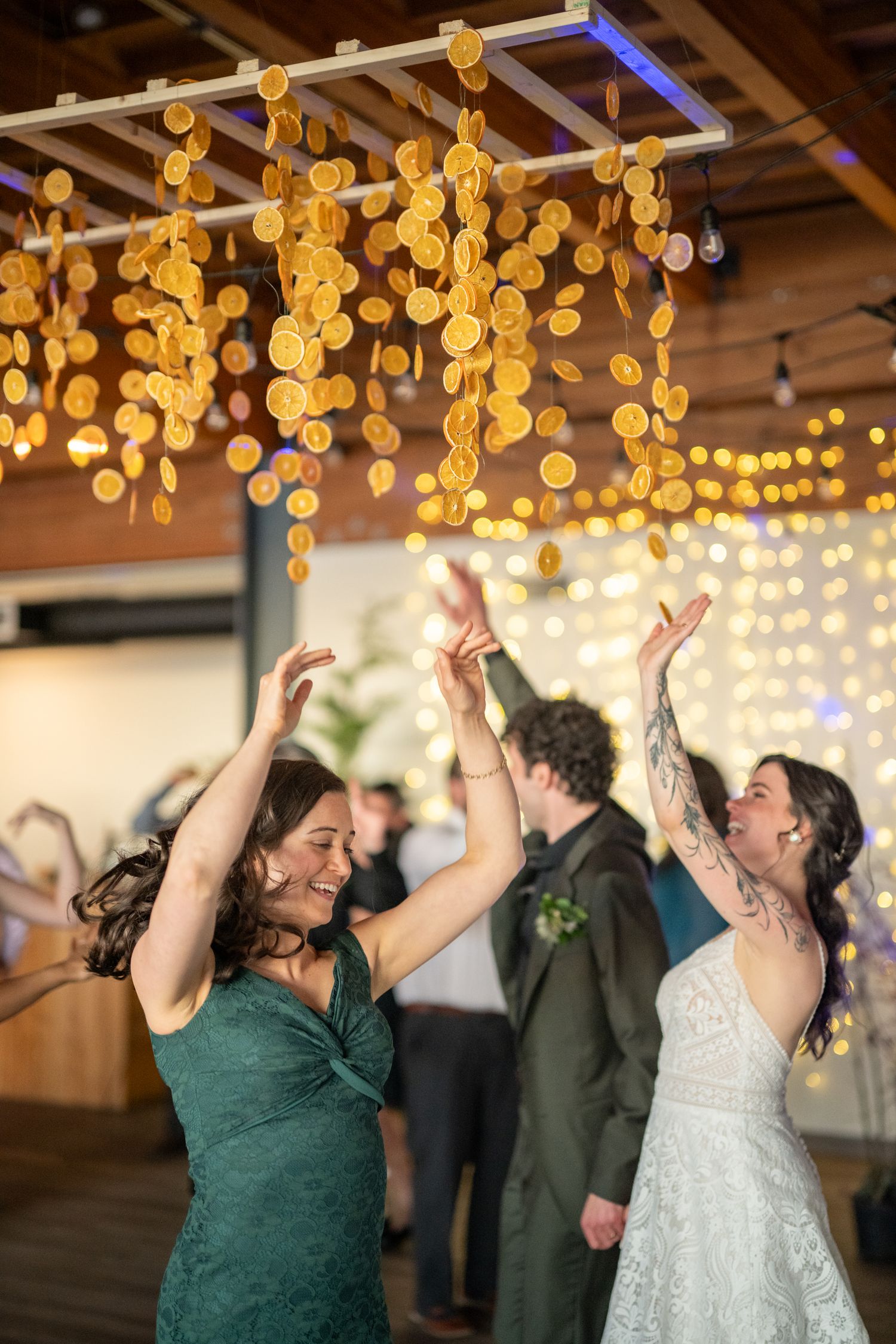 Dancers celebrating under golden pendant lights at a wedding reception venue.