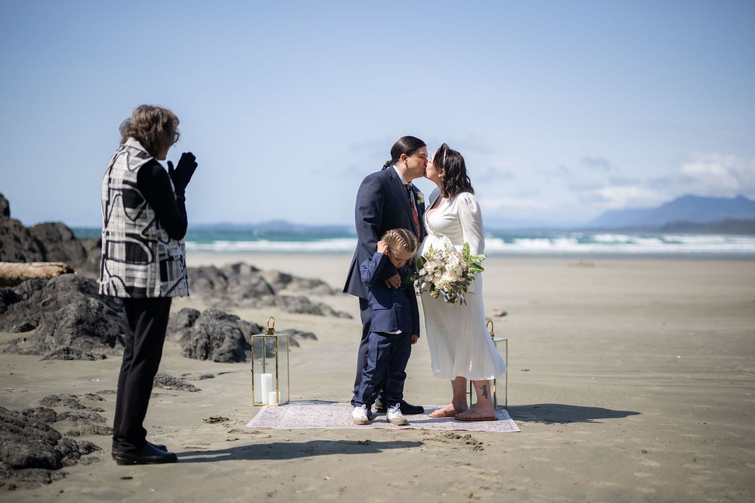 Wedding ceremony decor featuring lanterns and natural elements on a scenic beach.