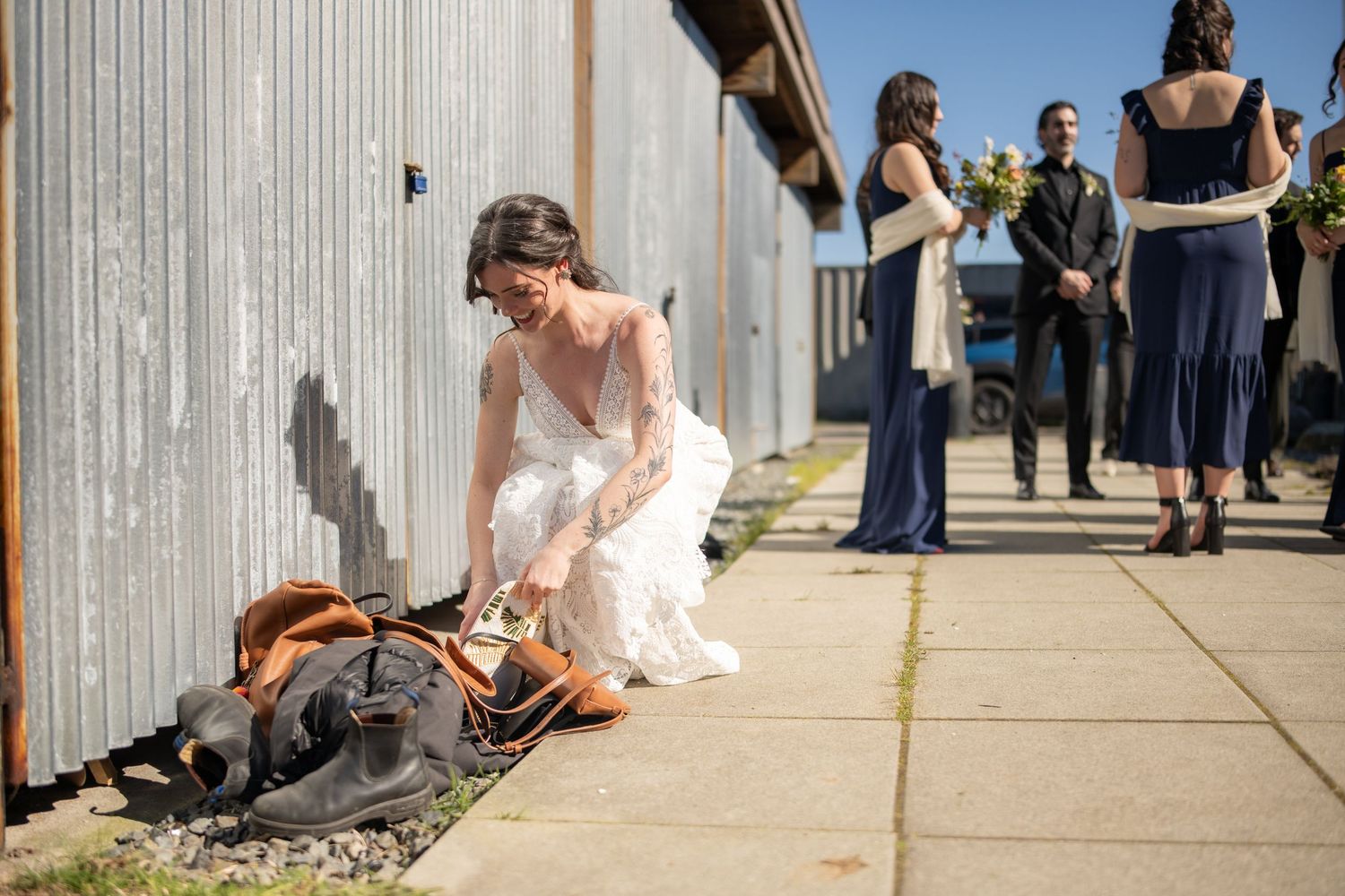 Wedding party walking along rustic wooden walkway outdoors.