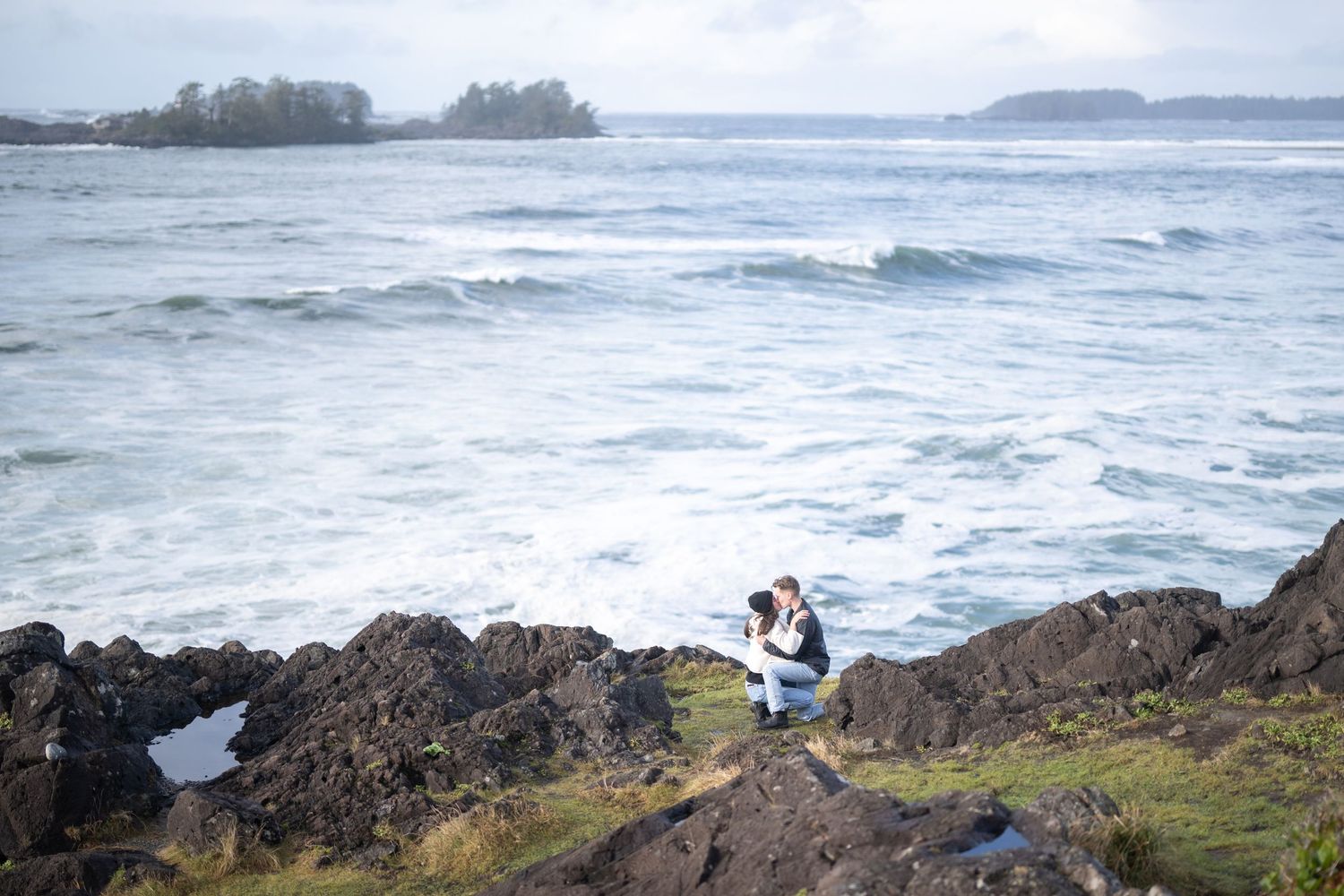 Scenic coastal landscape with rocky outcrops and crashing waves on a cloudy day.