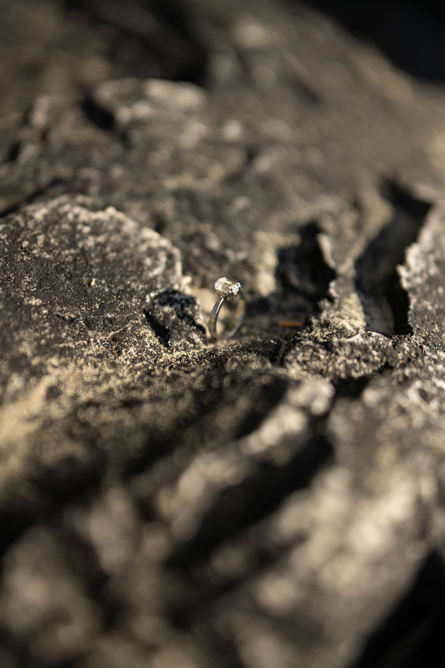 Close-up macro texture of dark rough stone or mineral surface with shallow depth of field.