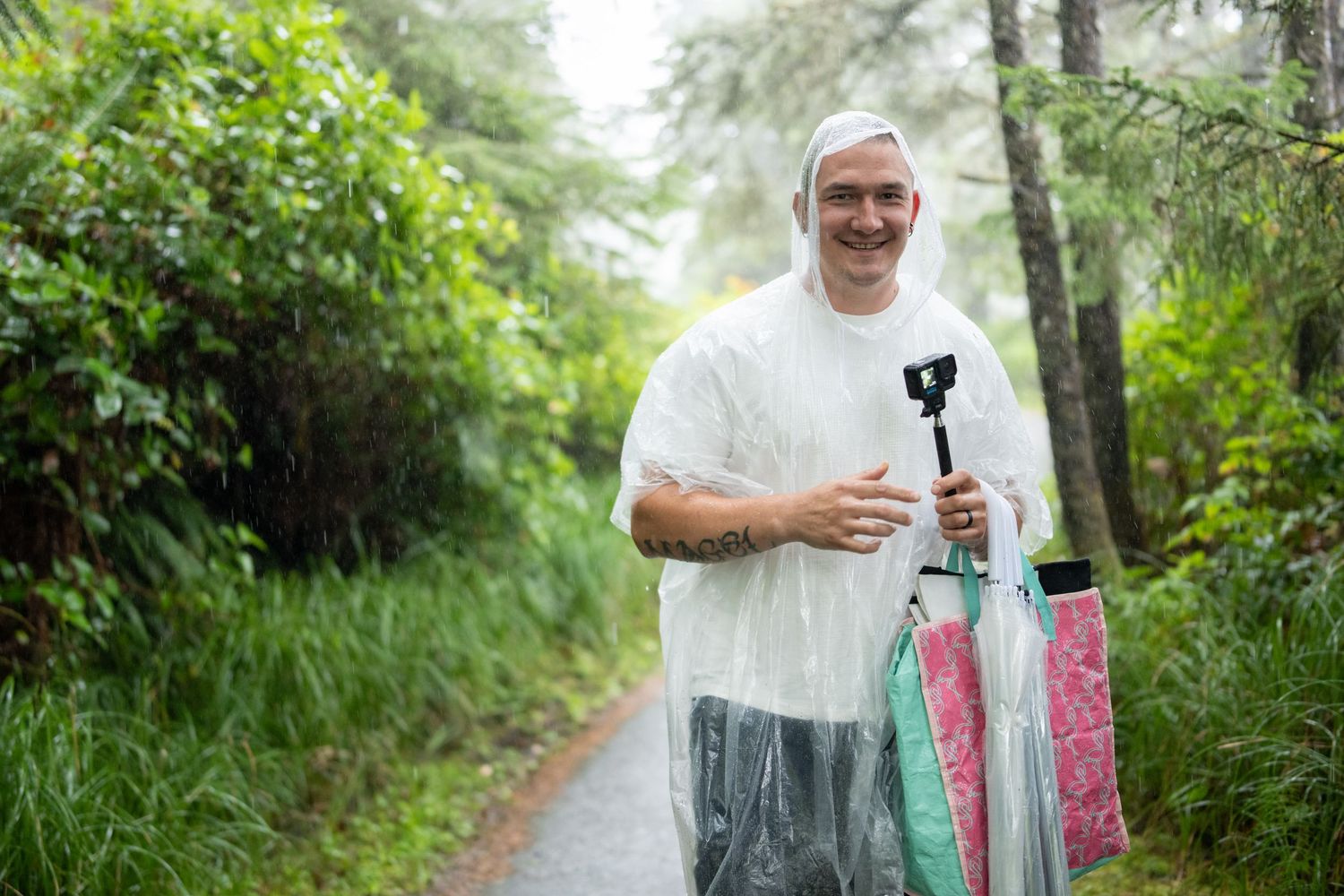 Couple walking along misty forest trail with umbrellas.