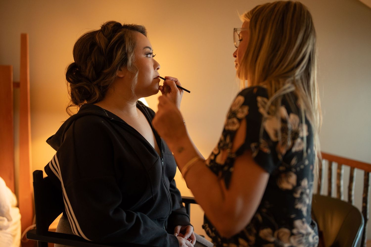 Wedding preparation scene with makeup application in warm lighting.