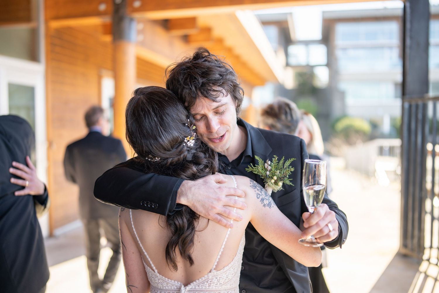 Wedding guests sharing joyful embraces and congratulations during a celebration.