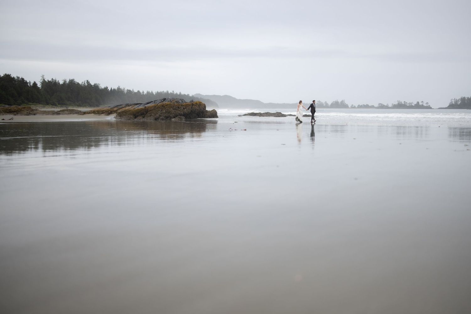 Expansive tidal flats stretch across a moody Pacific Northwest beach.