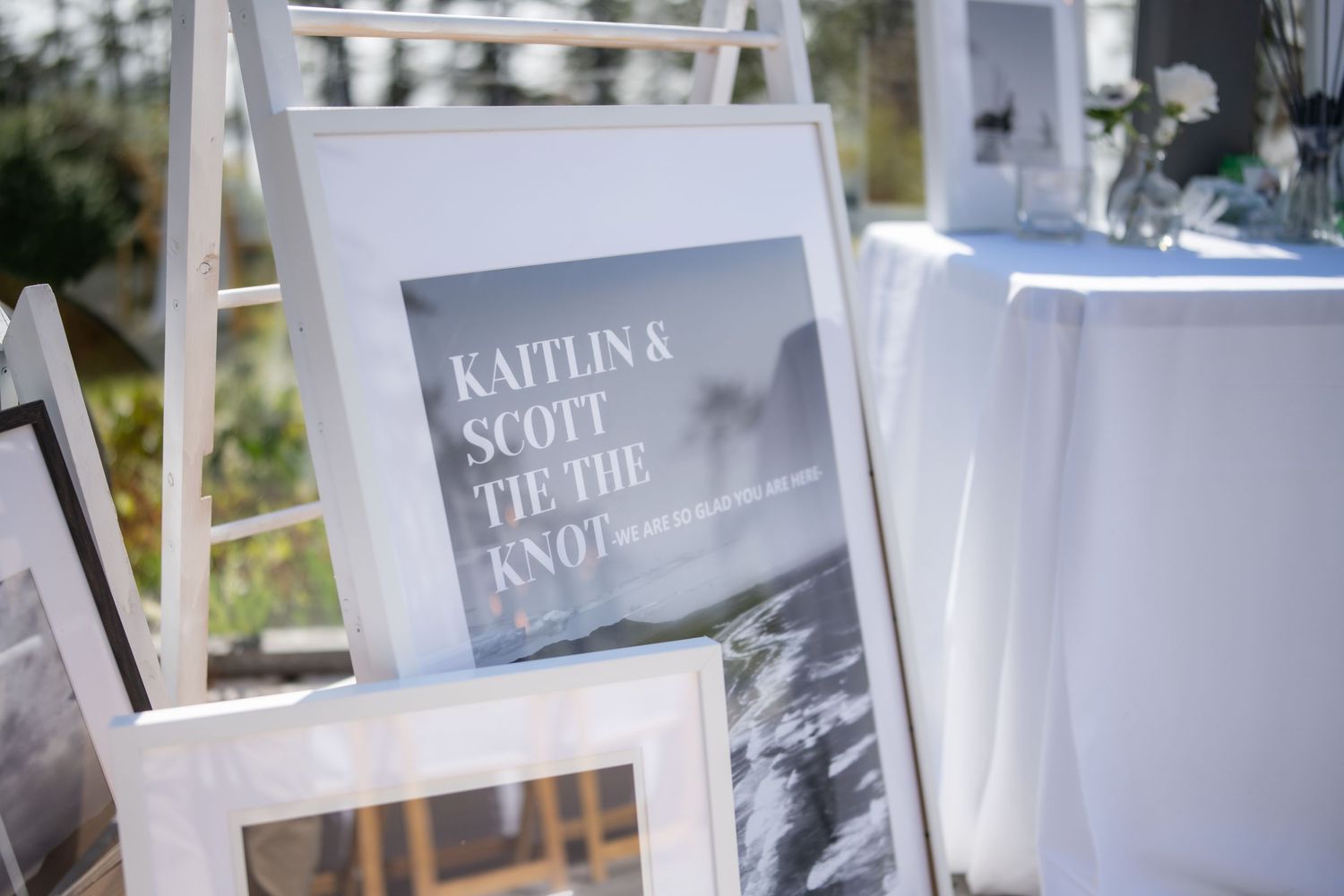 Wedding signage and photo displays arranged on white boards.