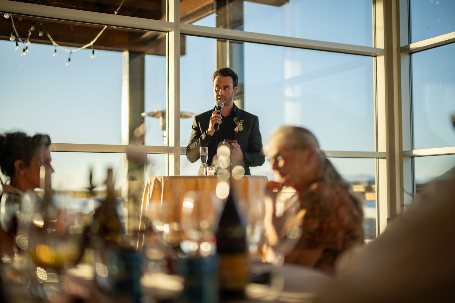 Panoramic view of a waterfront wedding venue with floor-to-ceiling windows.