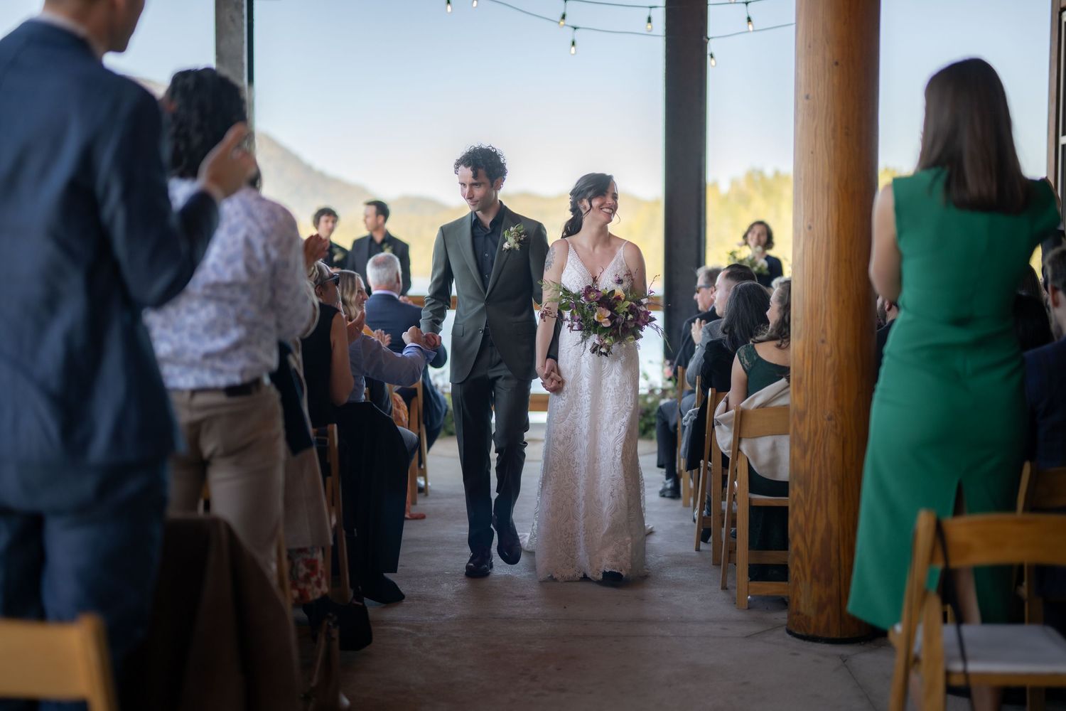 Elegant wedding reception space with wooden beams and string lights creating a warm atmosphere.