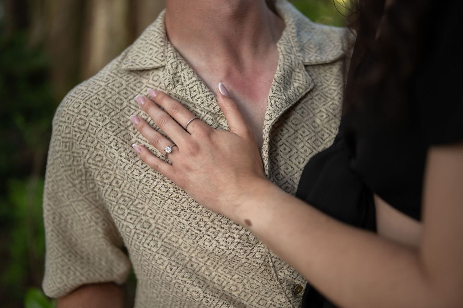 Close-up shot of hands and clothing details in natural lighting.
