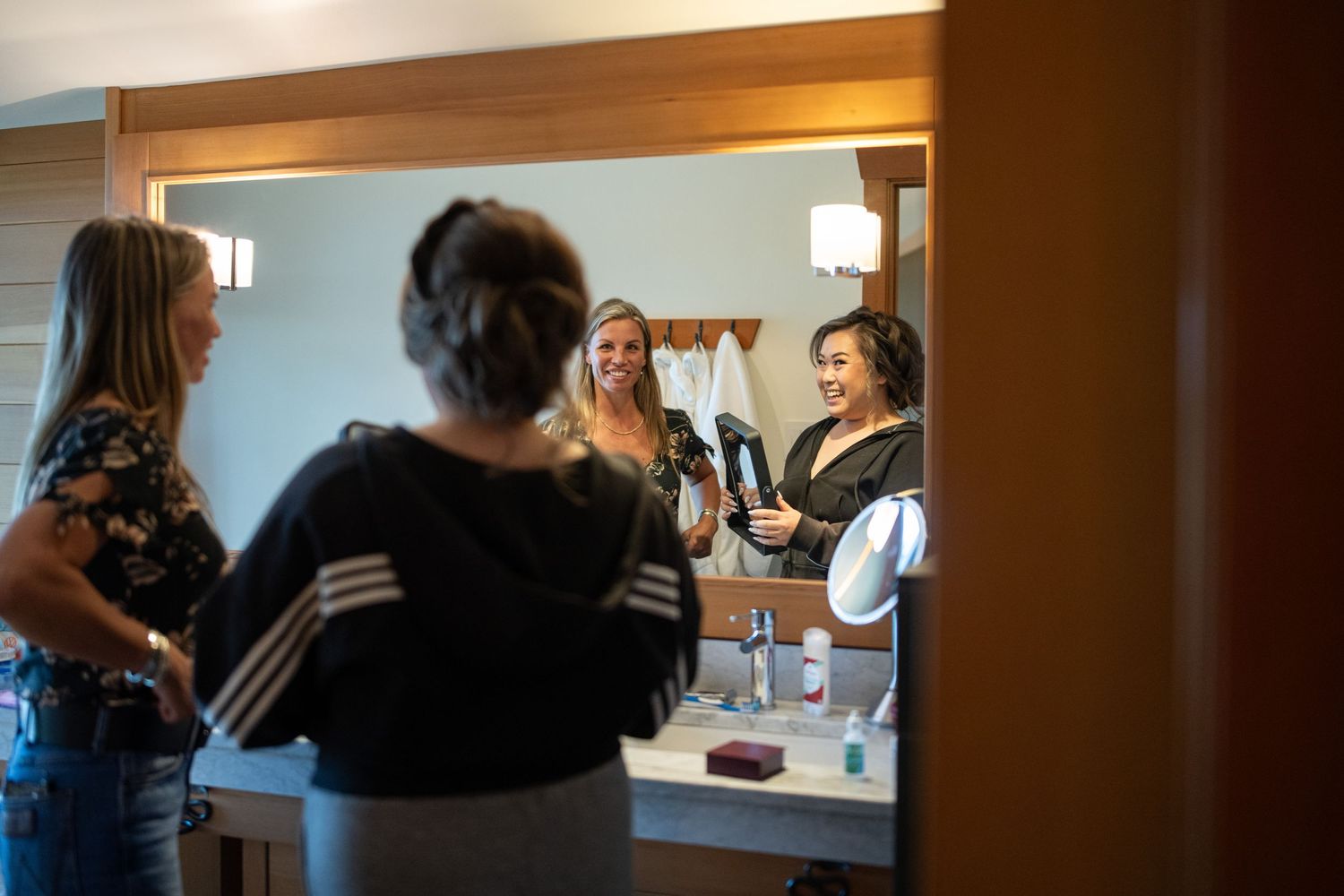 Wedding preparations underway with makeup artists working in a warmly lit room.