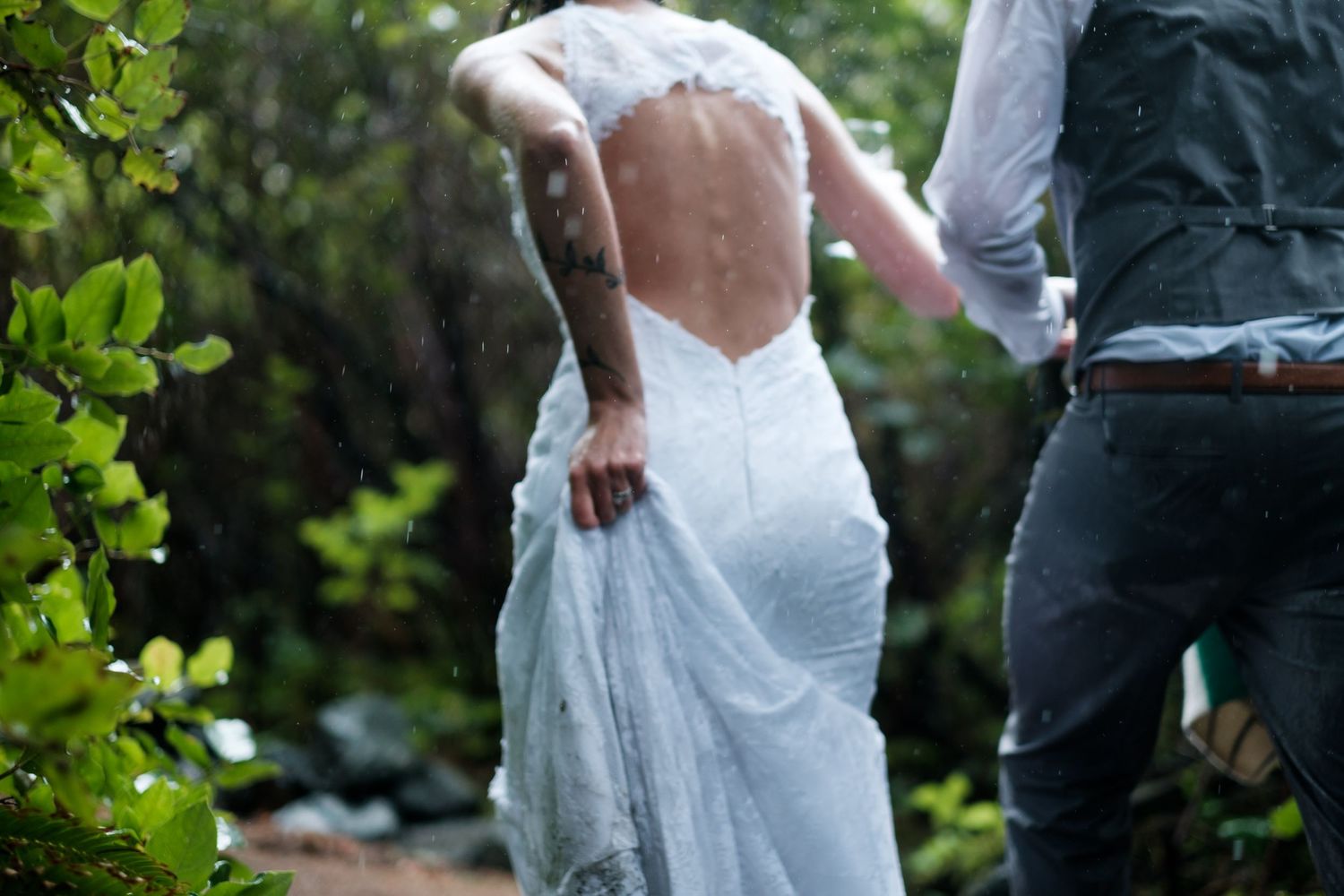 Wedding couple poses in natural outdoor garden setting.