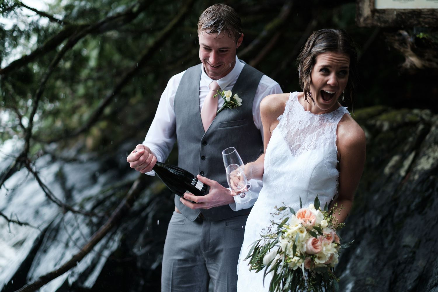 Wedding couple celebrates with champagne in a forest setting.