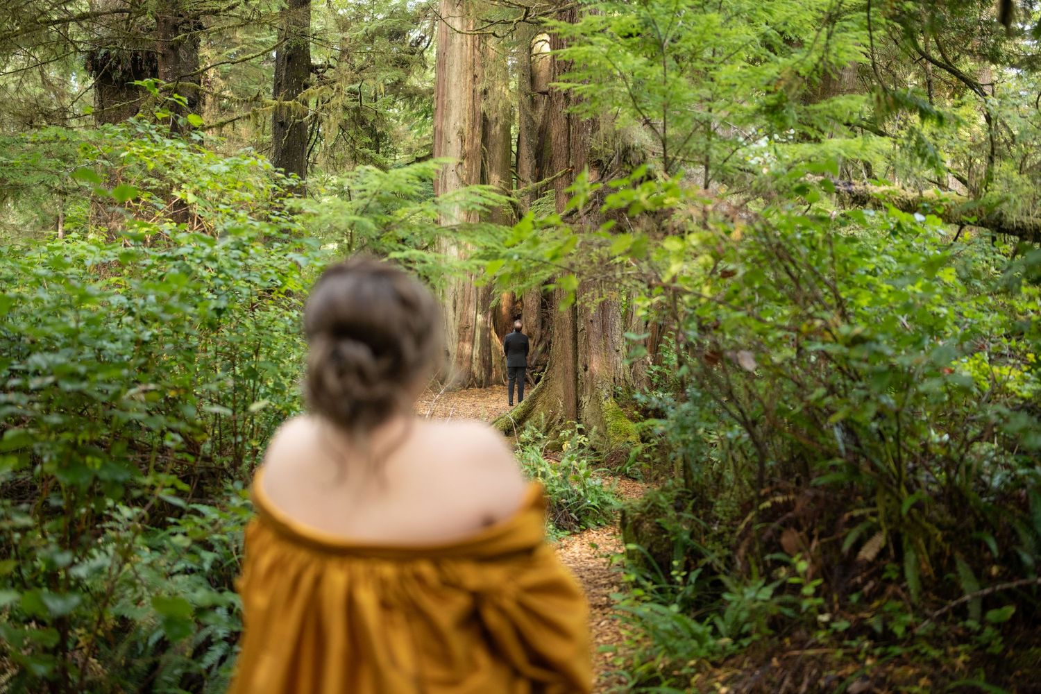 A mustard yellow dress contrasts beautifully with the verdant forest setting.