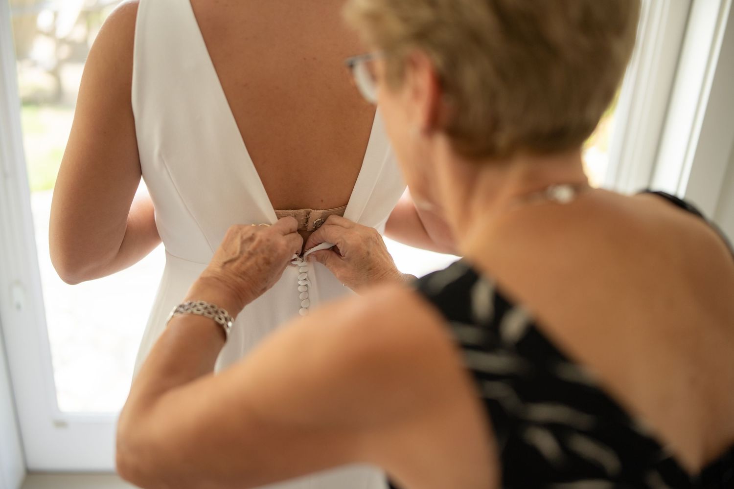 Getting ready scene with elegant white dress details.