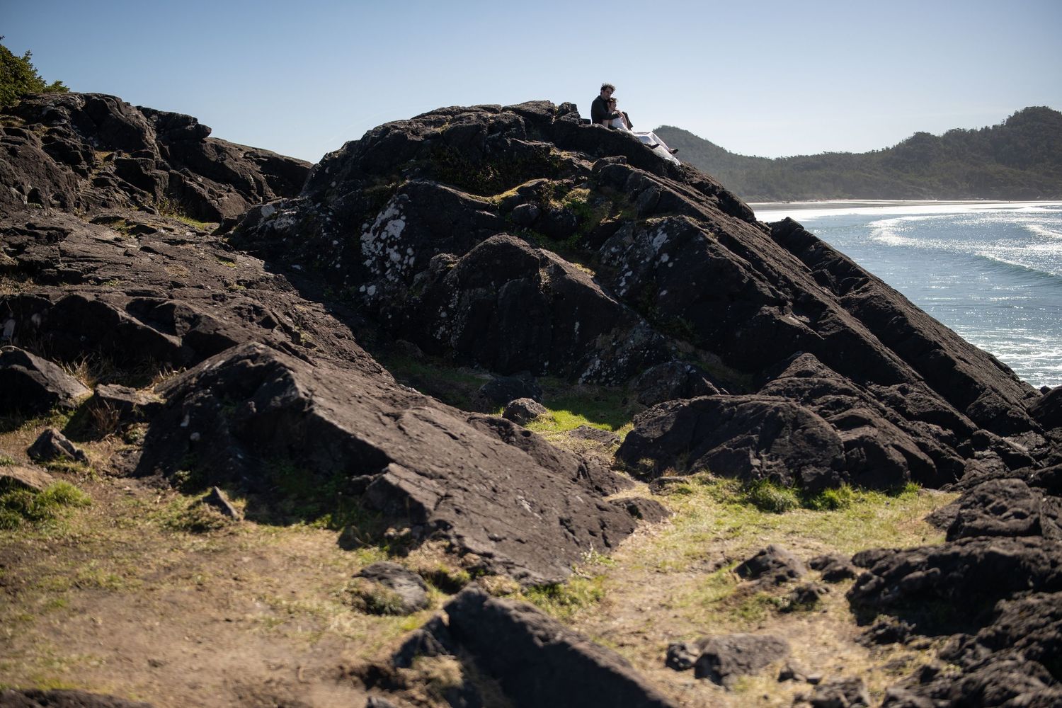 Sweeping view of rocky coastal cliffs with ocean waves crashing below.